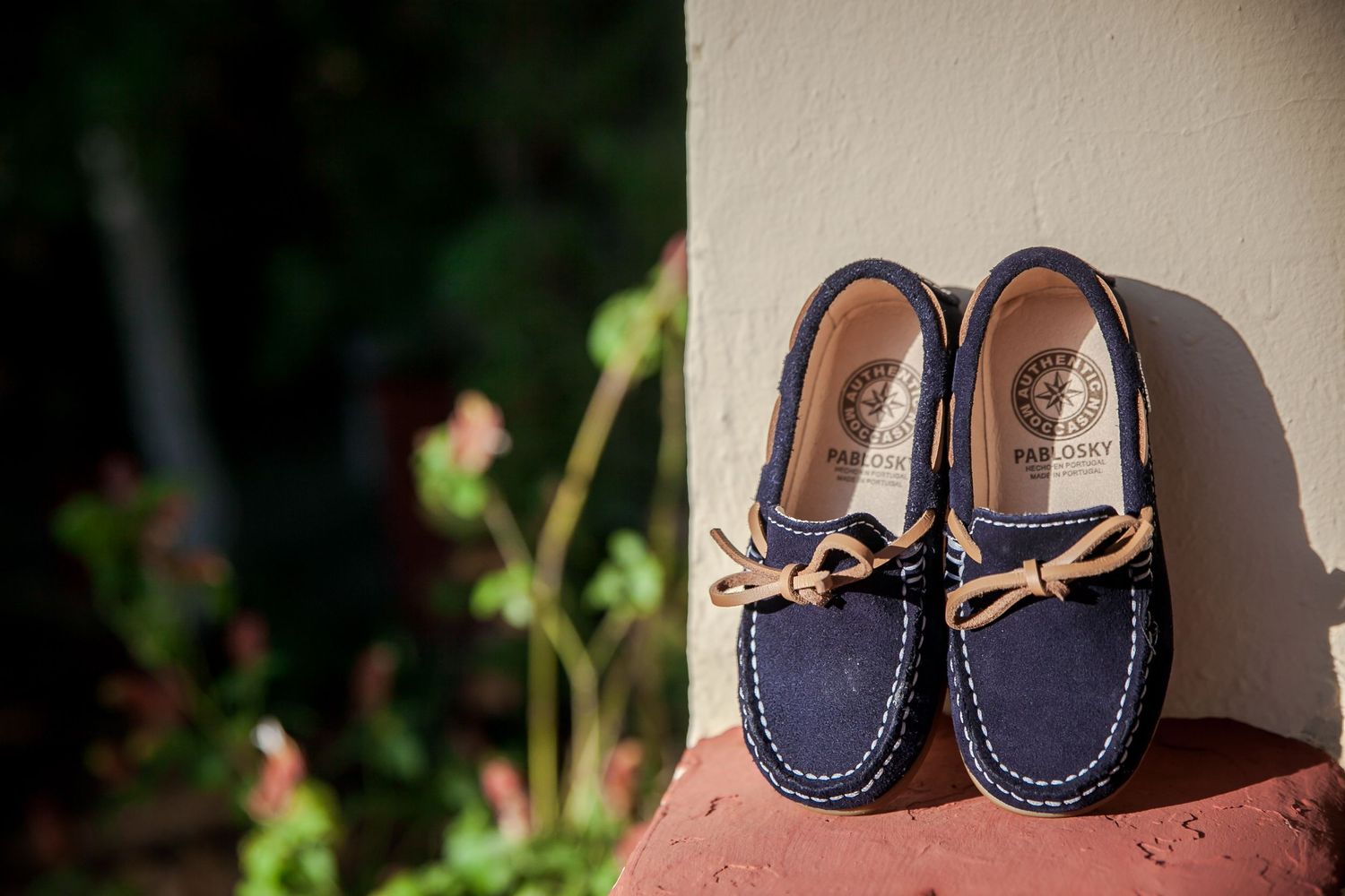 Collection of navy blue baby moccasins lined up on display.