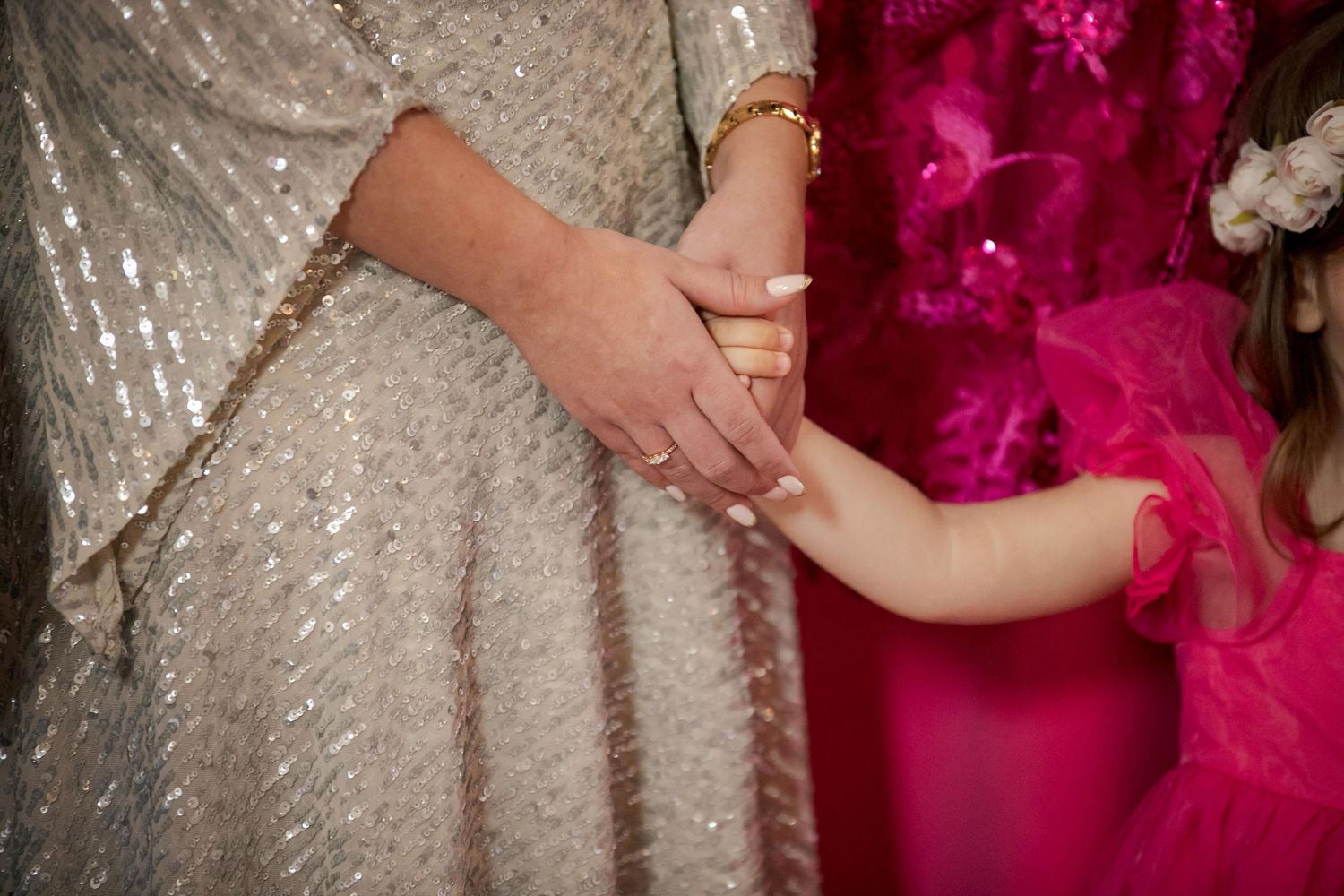 Detail shot of sparkly dress with pink accent colors in background.