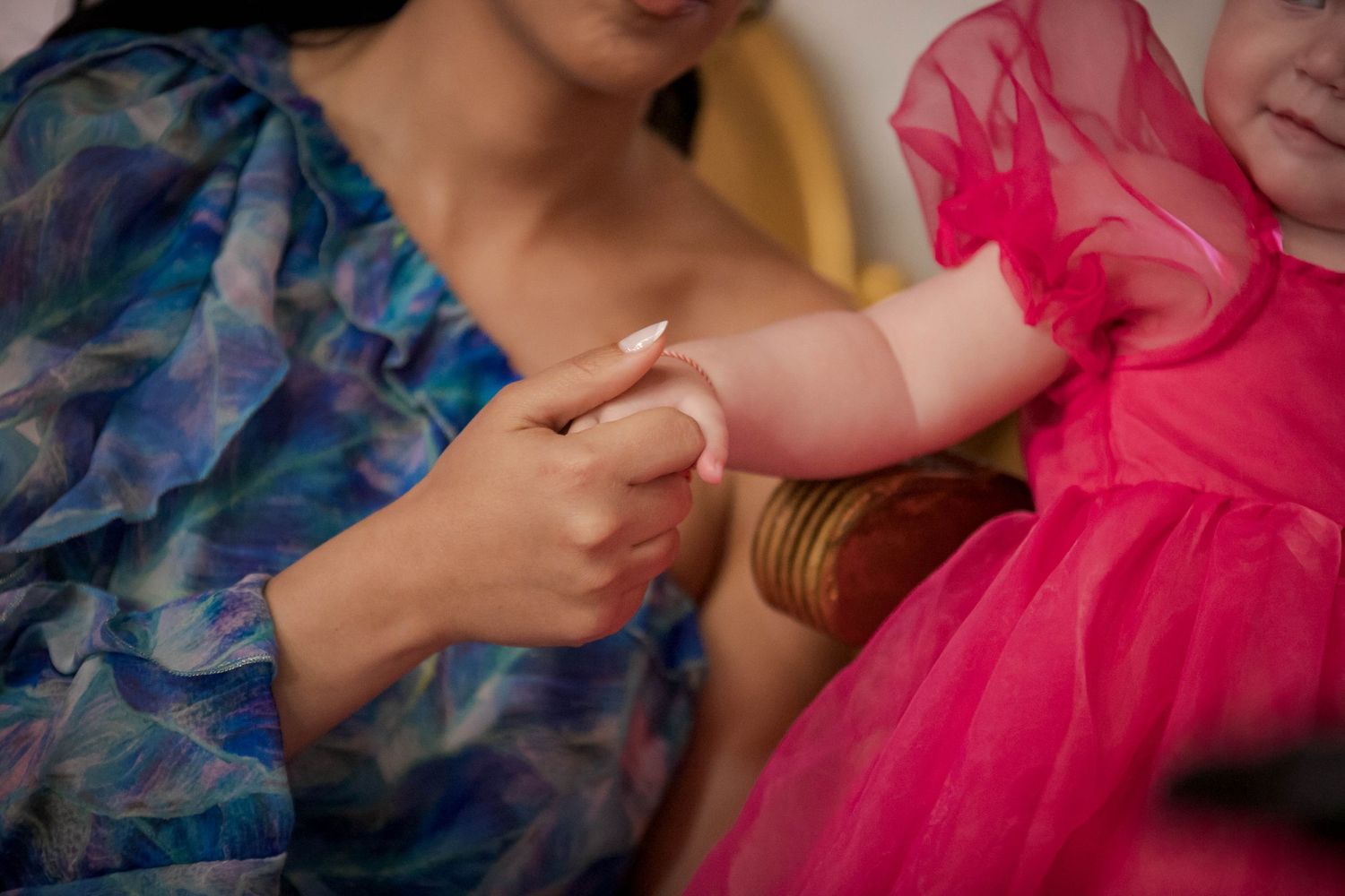 Close-up details of pink and blue formal attire accessories at an elegant event.