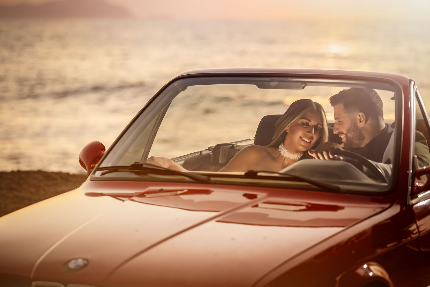 Romantic sunset portraits in classic car showing warm golden light and vintage style.