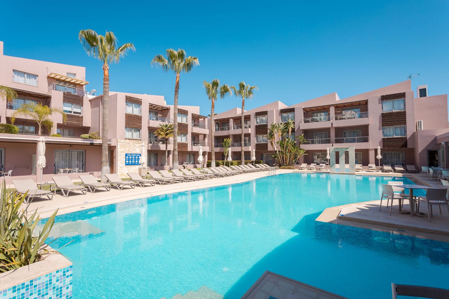 Luxury beachfront resort featuring turquoise swimming pool and contemporary architecture.