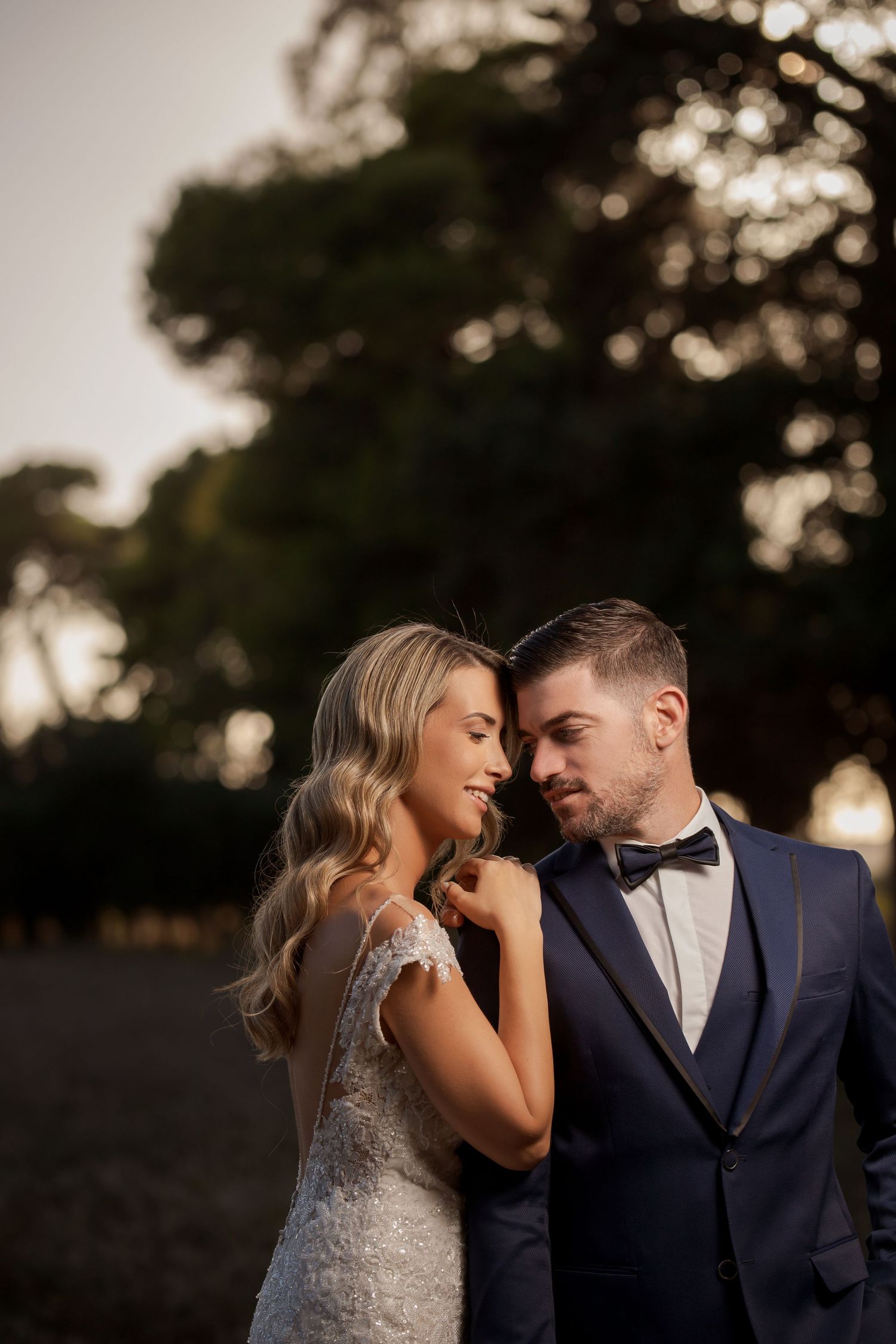 Romantic golden hour wedding portraits with couple in formal attire.