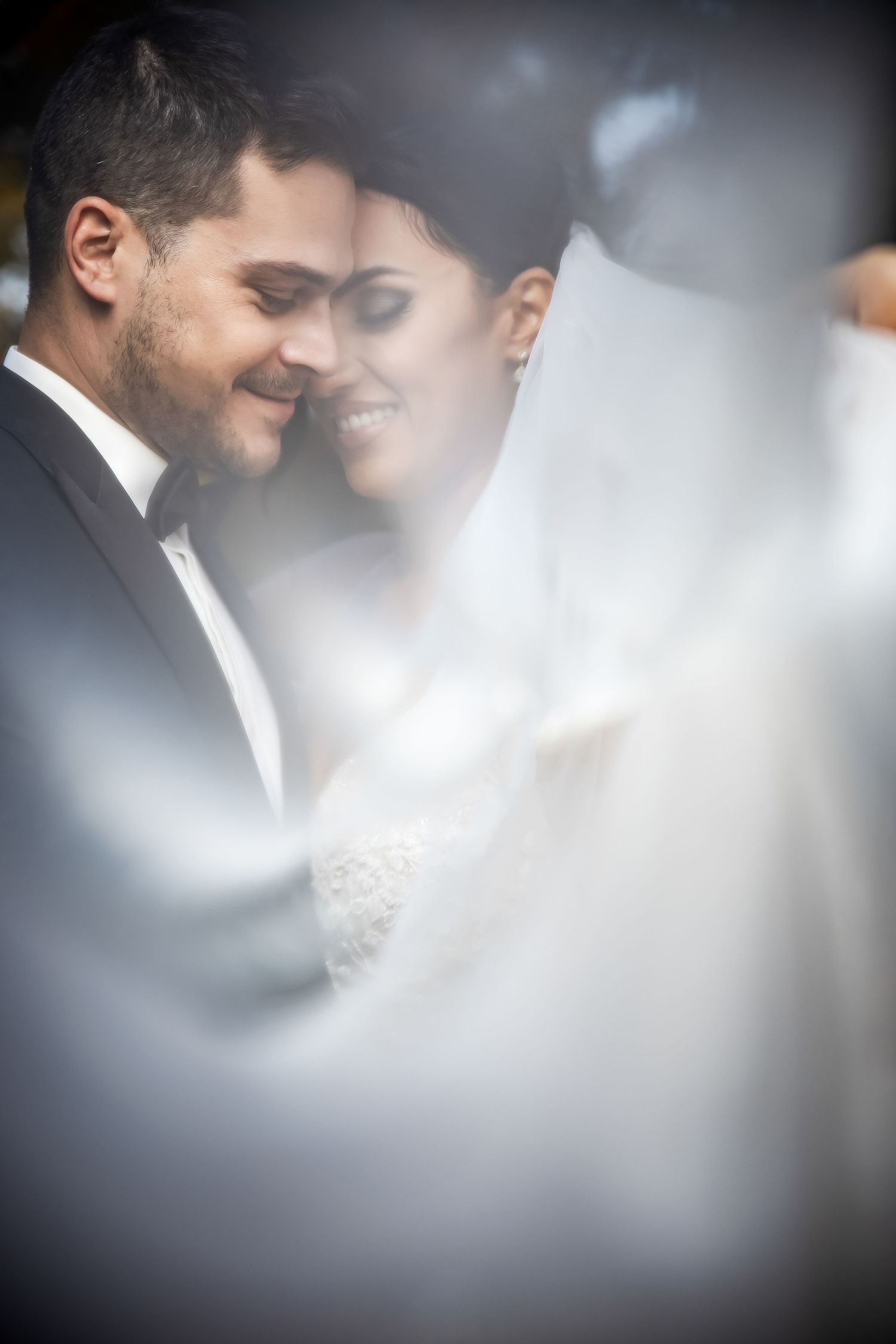 Artistic close-up wedding portrait with dreamy bokeh effect.