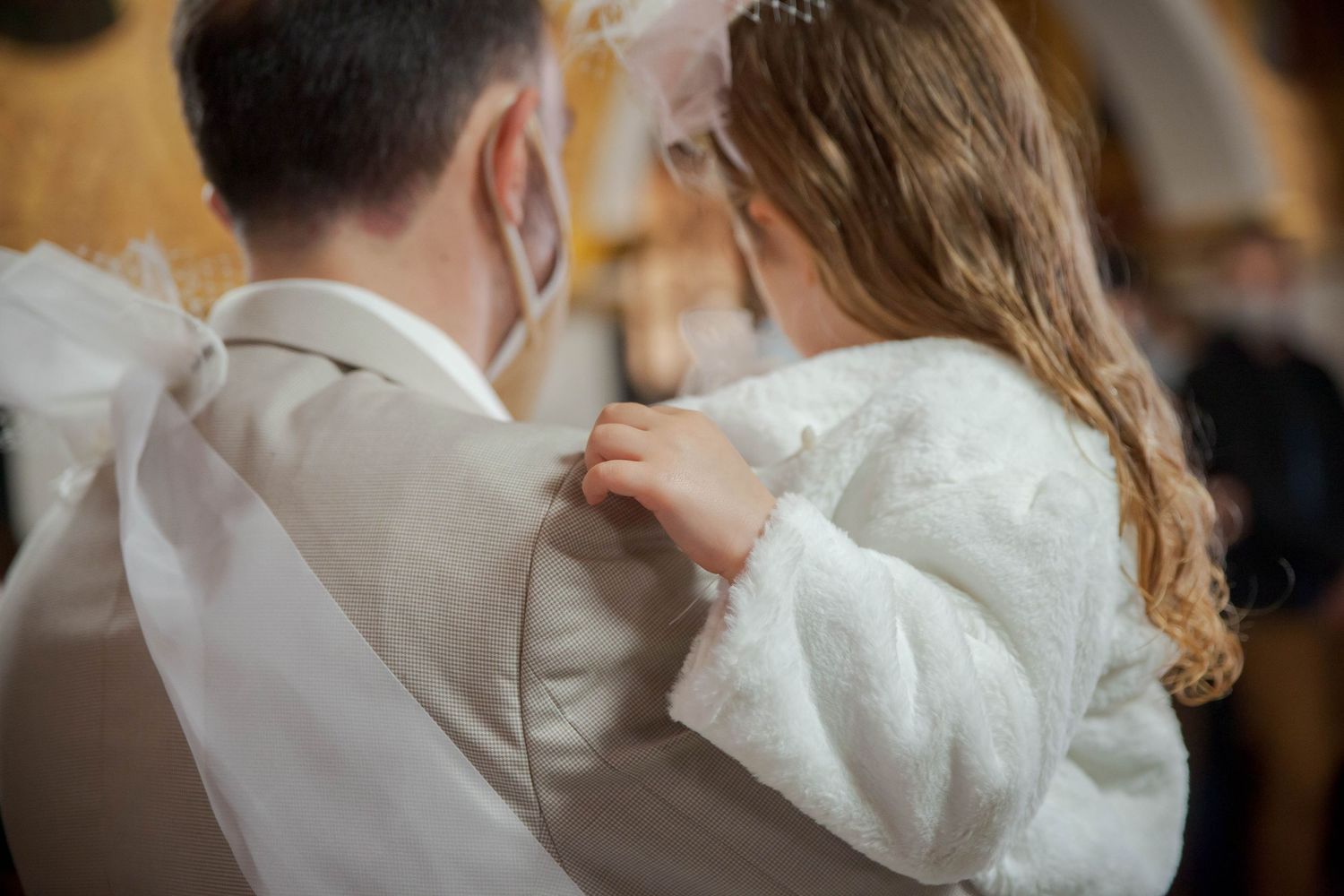 Romantic close embrace between couple in wedding attire.