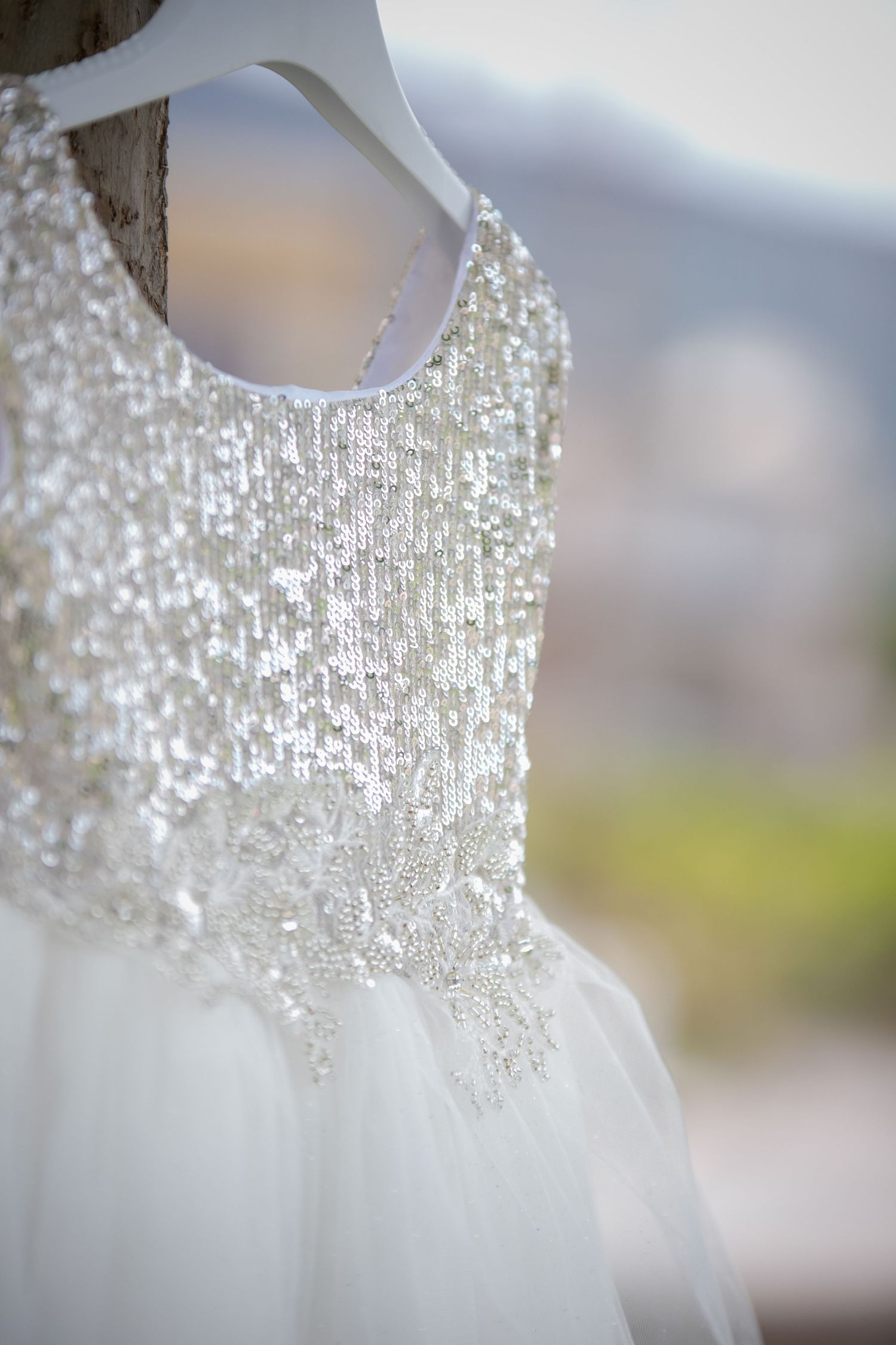 Close-up of a white wedding dress bodice with intricate beading and sequin details.