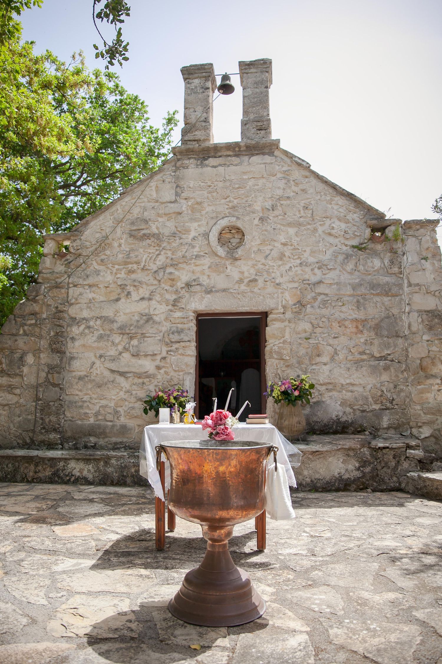 Stone chapel exterior with rustic altar and white tablecloth setup.