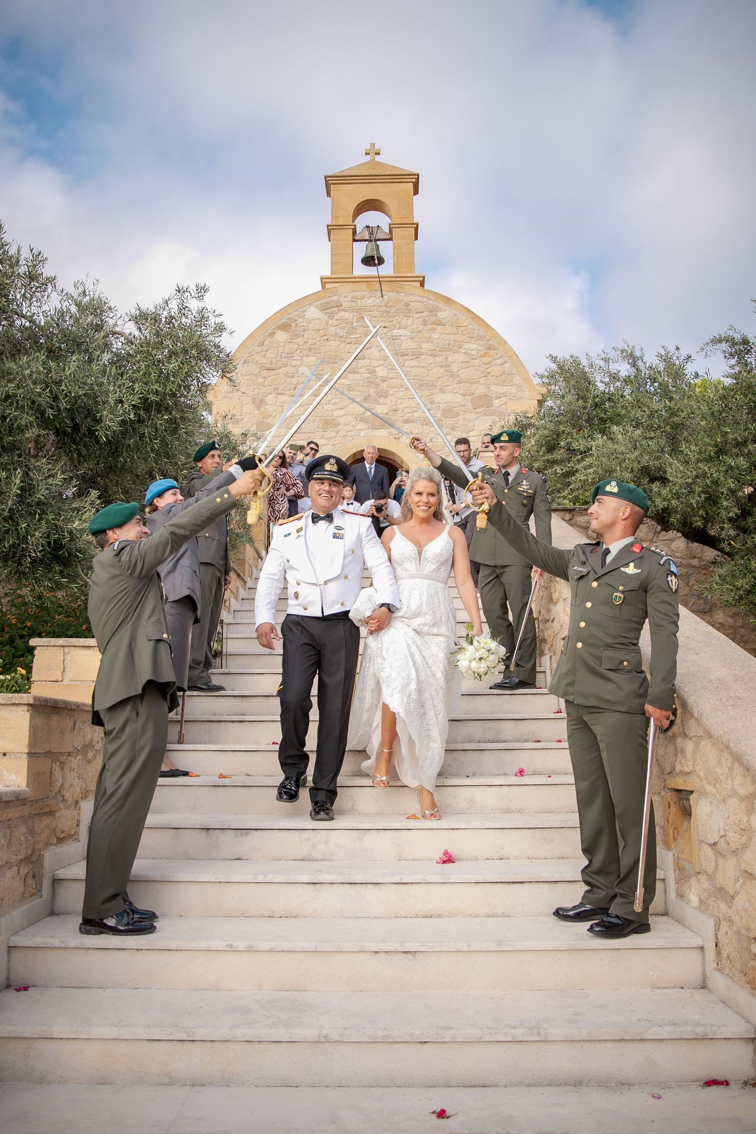 Military honor guard lines stone steps of chapel for newlyweds' grand exit.