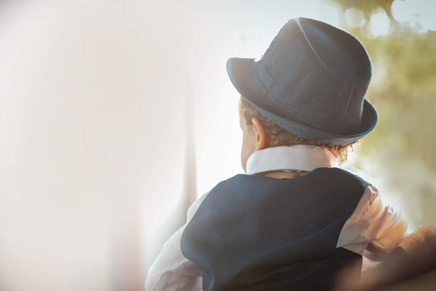 A row of dark silhouetted hats against a bright background.