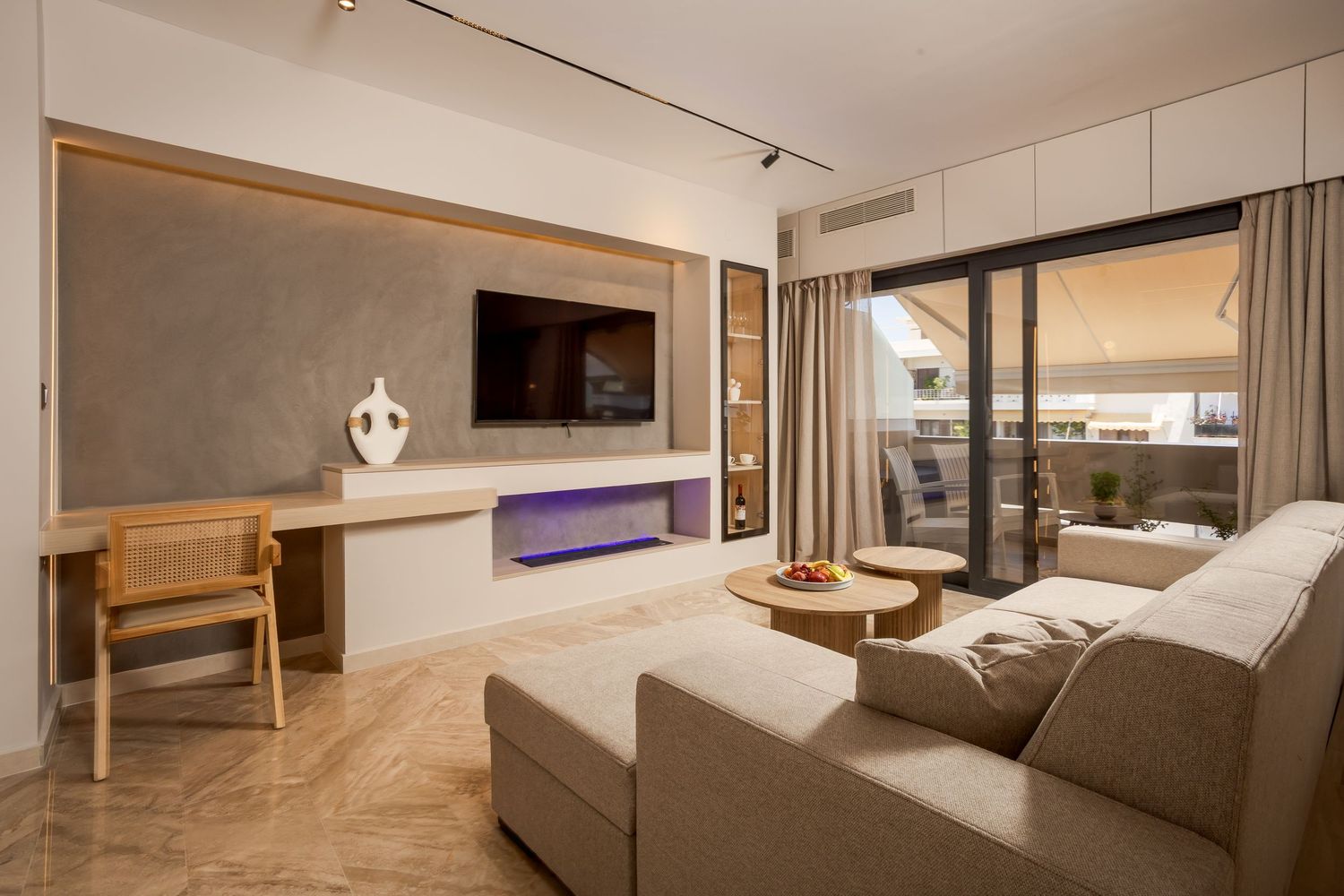 Modern luxury hotel suite interior with warm lighting, sleek furnishings and wooden accents shows connected living spaces.
