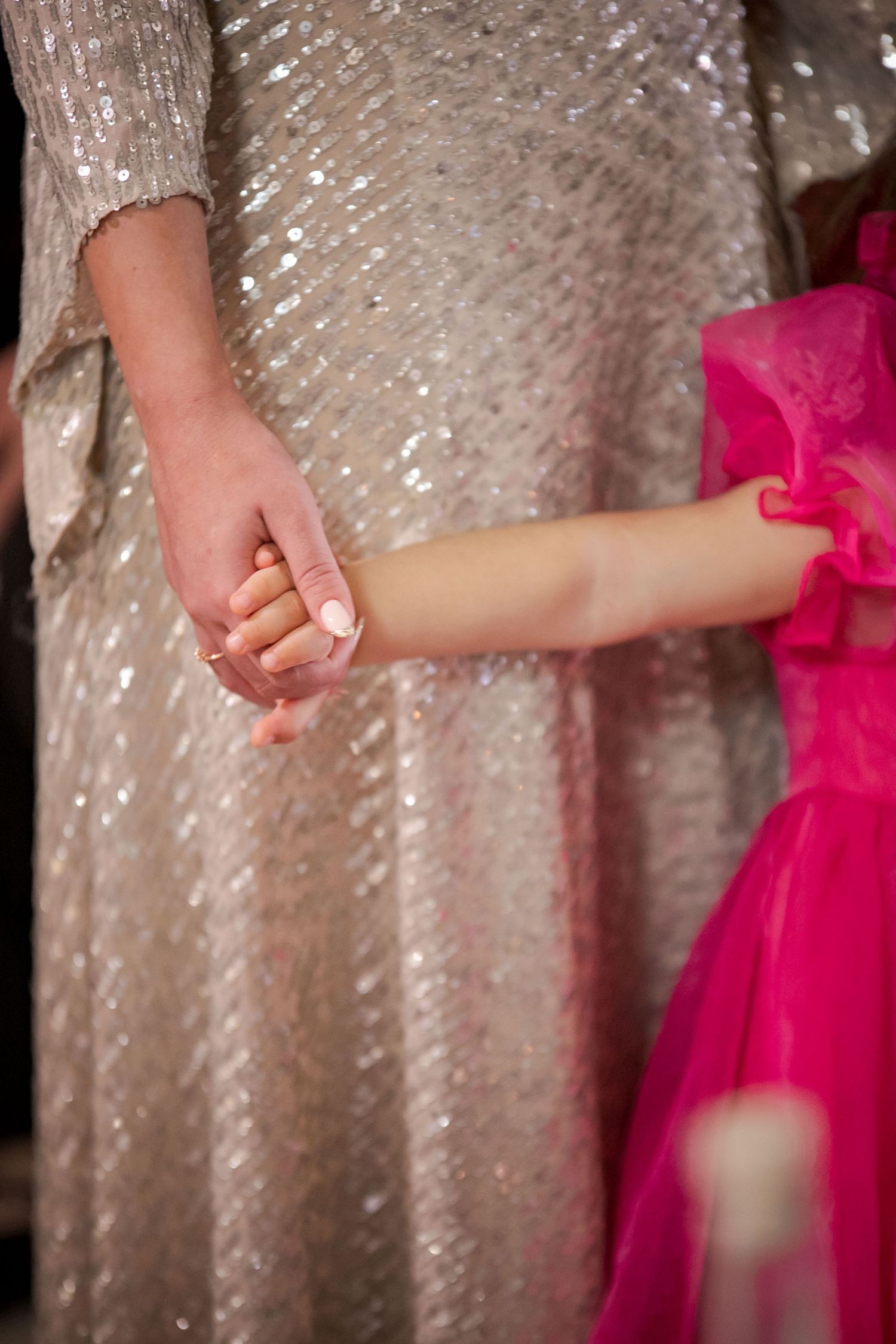 Elegant sequined dress detail with vibrant pink fabric accent.