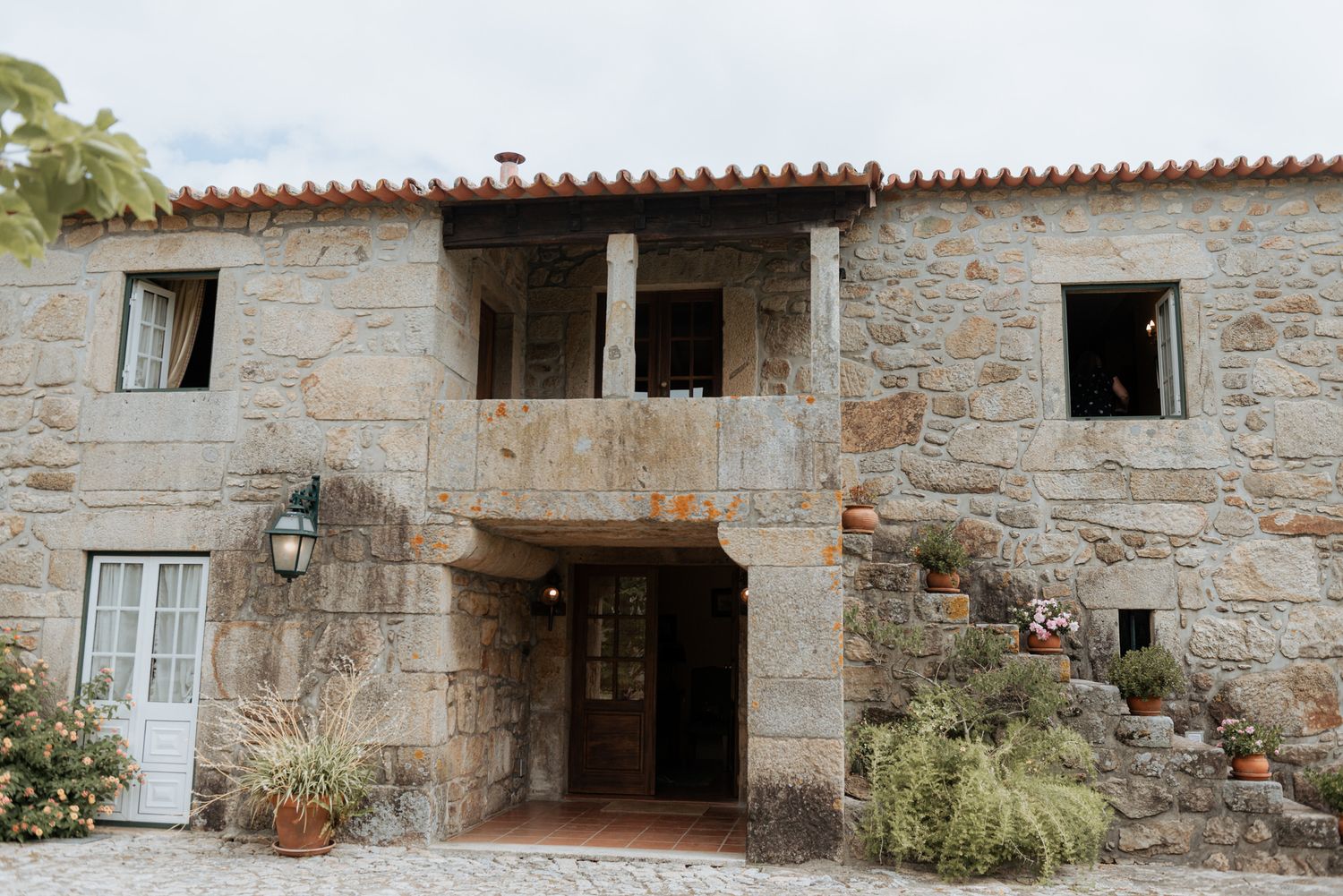 Stone farmhouse exterior detail showing rustic walls, windows and doorways in traditional Portuguese architectural style.
