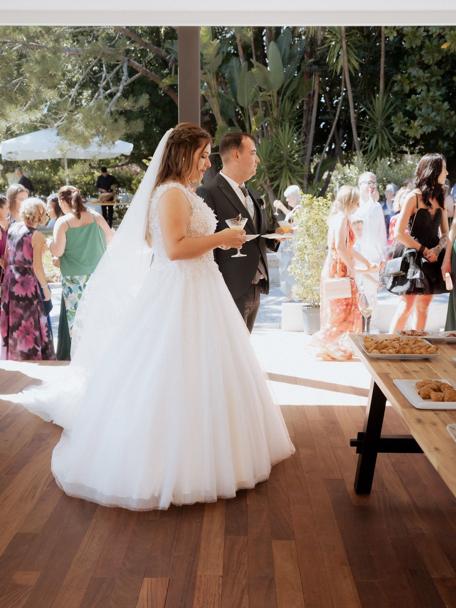 A wedding celebration under a covered patio area with guests gathered and a buffet table visible.