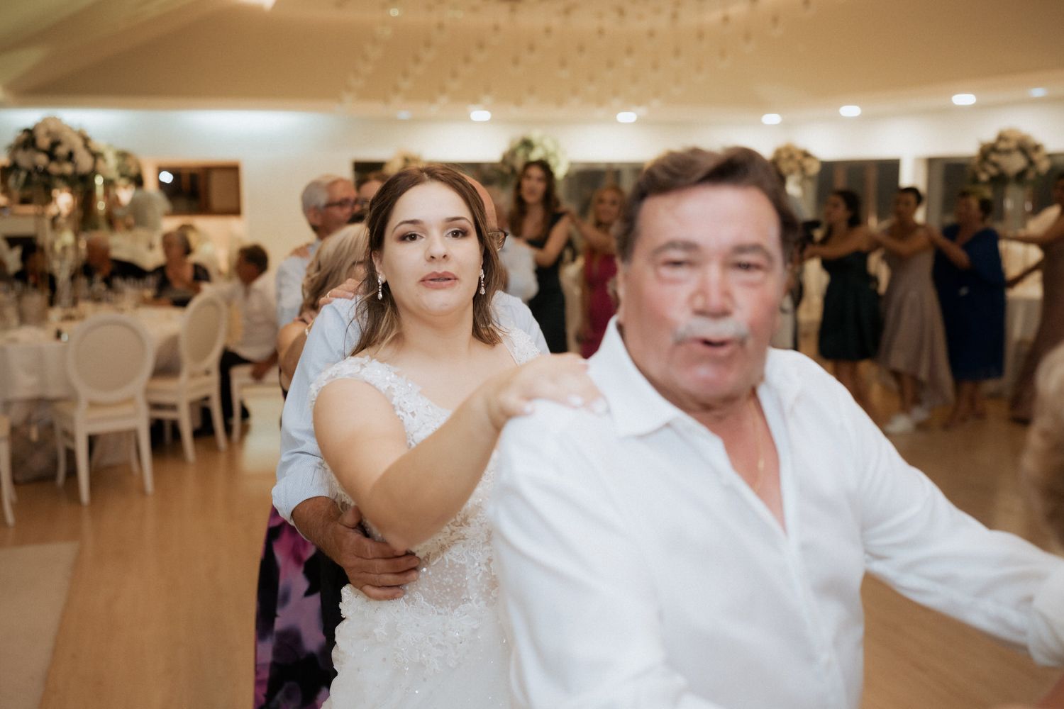 Fun dancing and celebration at a lively wedding reception in an elegantly decorated banquet hall.