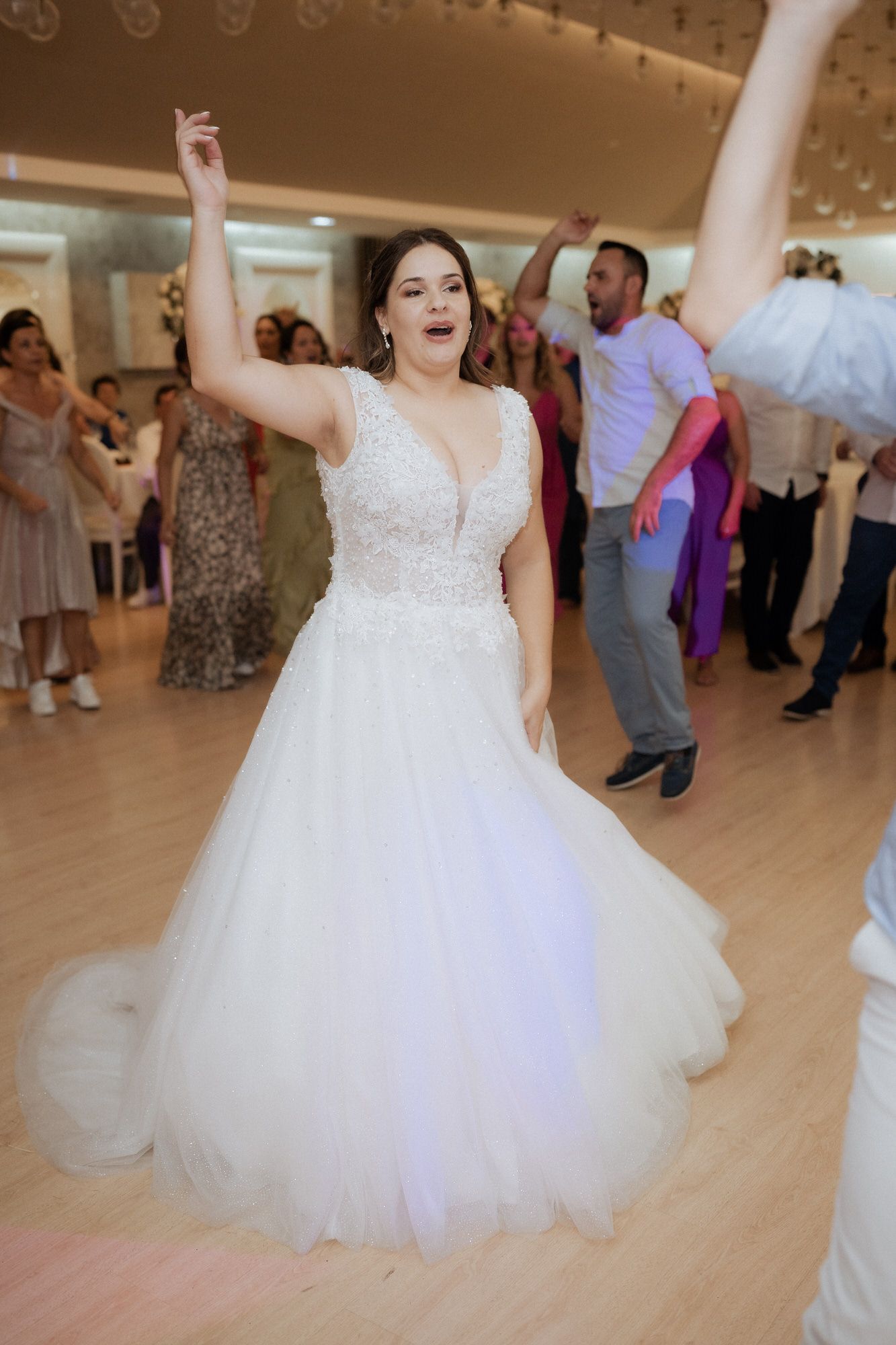 Bride in a flowing white ball gown twirls gracefully on the dance floor during a wedding celebration.