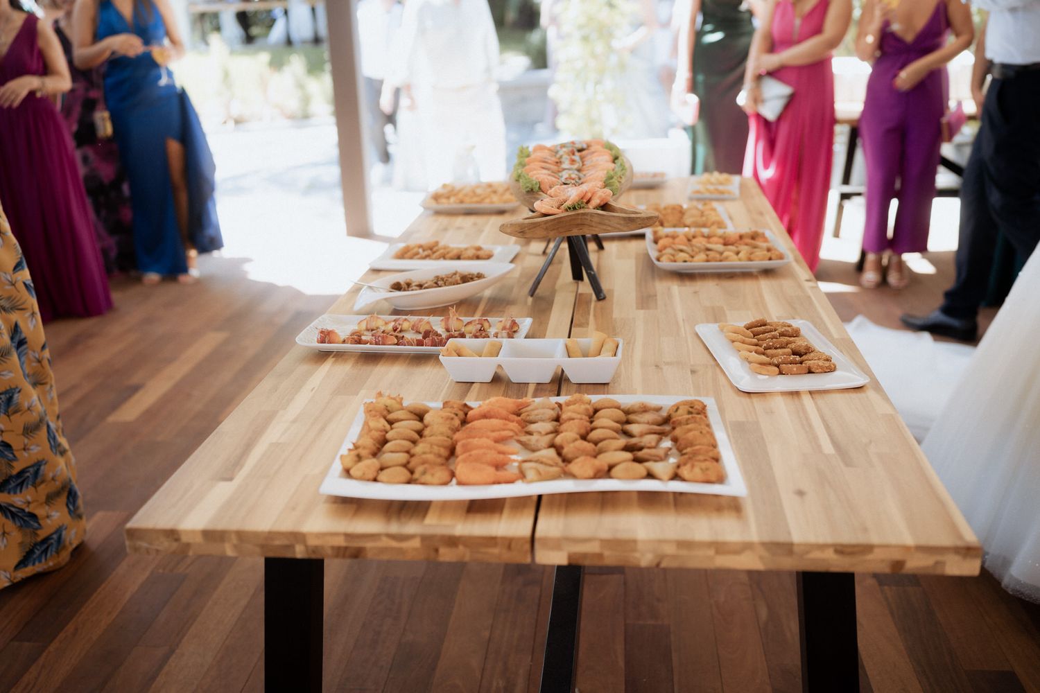 Table setup at a wedding reception displaying homemade chocolate chip cookies arranged on rustic wooden boards.