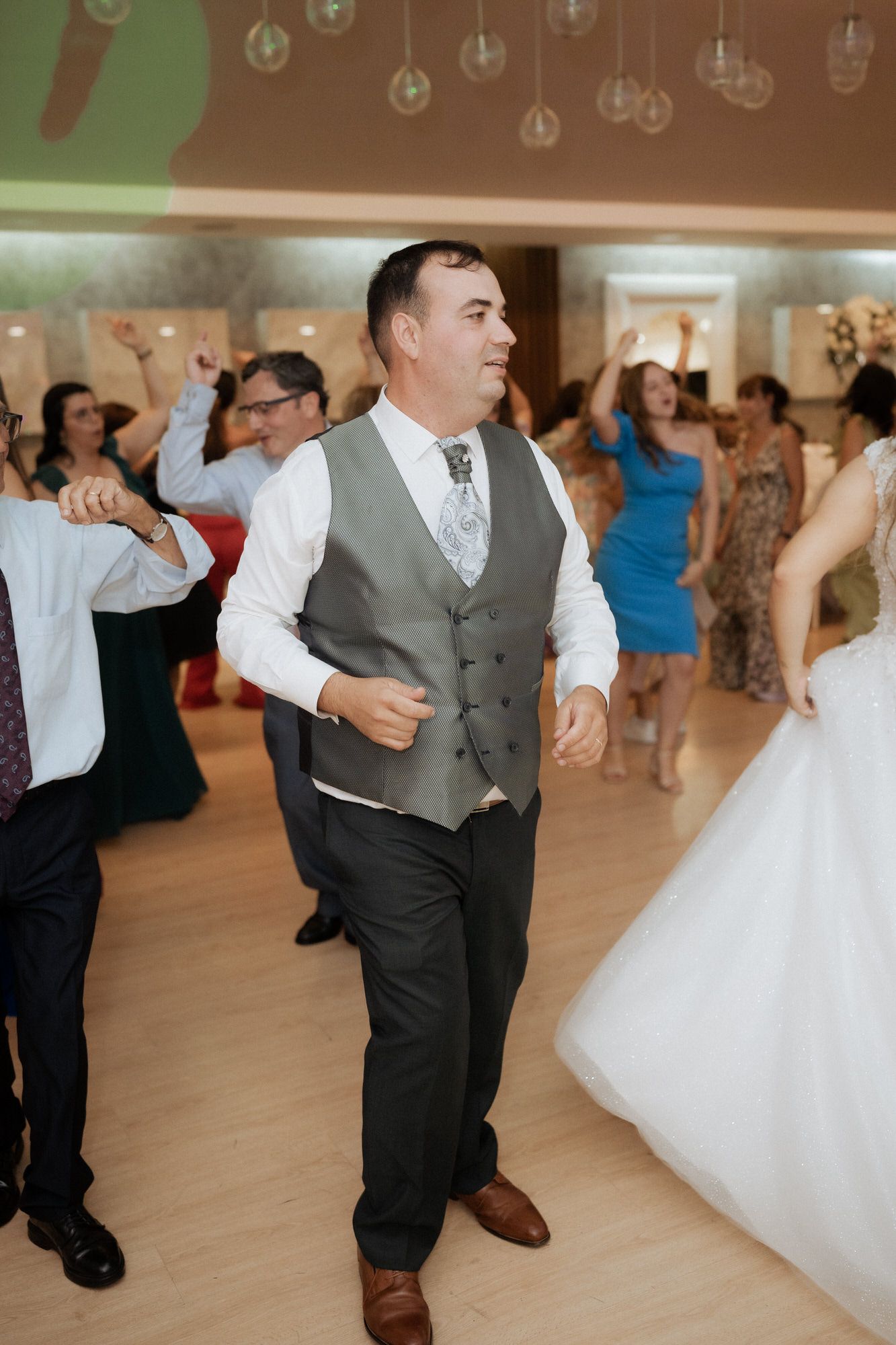People enjoy dancing at a wedding reception as the bride's white dress swirls on the dance floor.