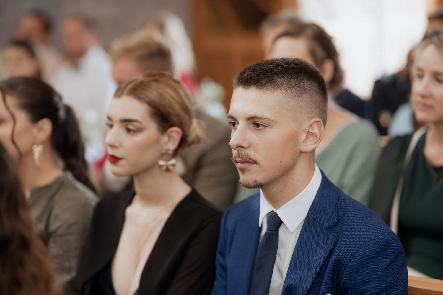 Attendees sit in rows at a professional conference or seminar with focused expressions.