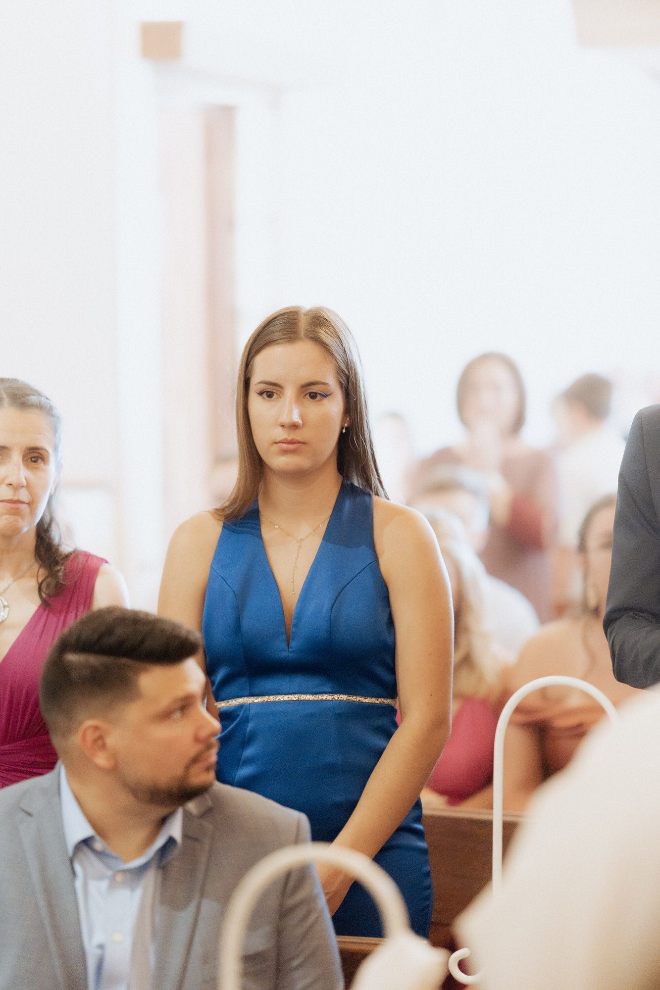 People sit in a bright office environment during what appears to be a business meeting or conference.