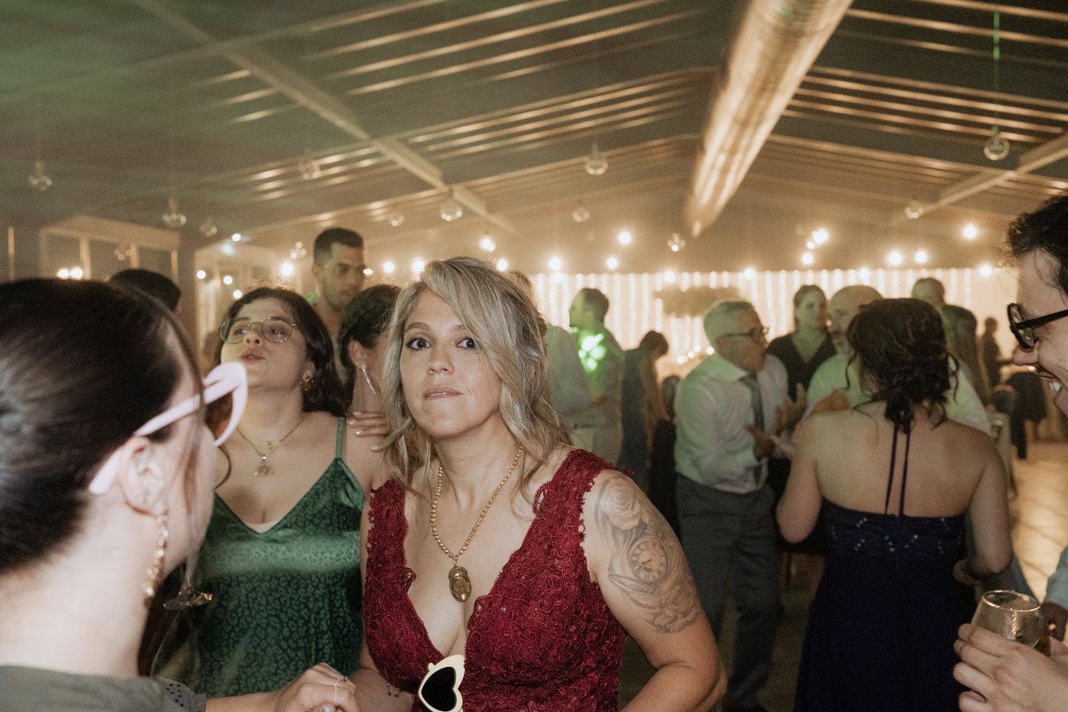 Party guests enjoying a lively indoor celebration with warm lighting and formal attire at an evening event.