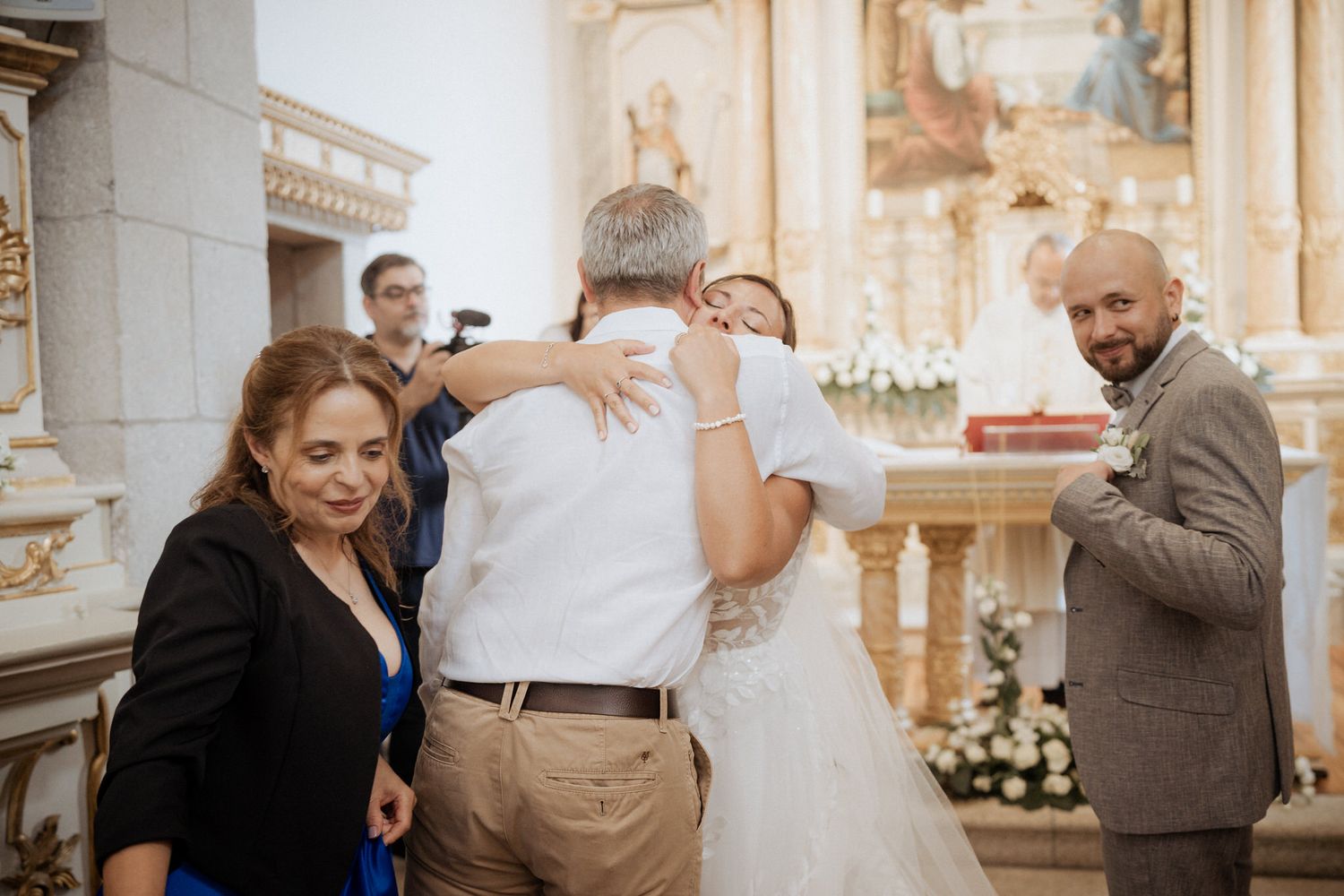 A wedding ceremony in progress inside an ornate church with marble columns and religious artwork.