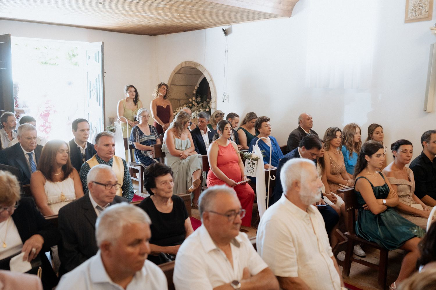 A crowded indoor gathering shows attendees seated in rows watching attentively during an event.