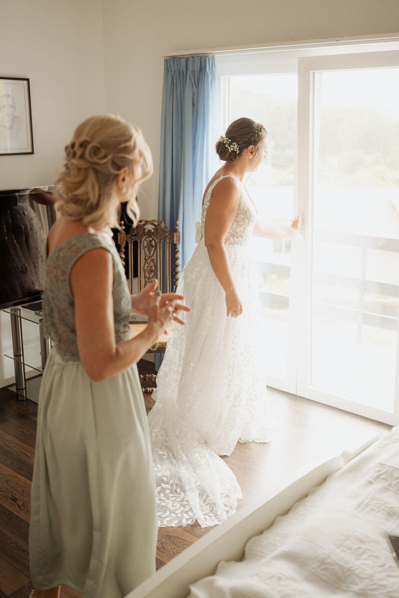 Wedding morning scene with sunlit interior showing two figures in formal attire by a bright window.