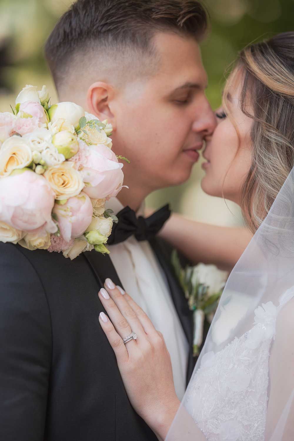 A romantic wedding portrait series showing tender moments between a bride and groom with soft pink and white bouquet accents.