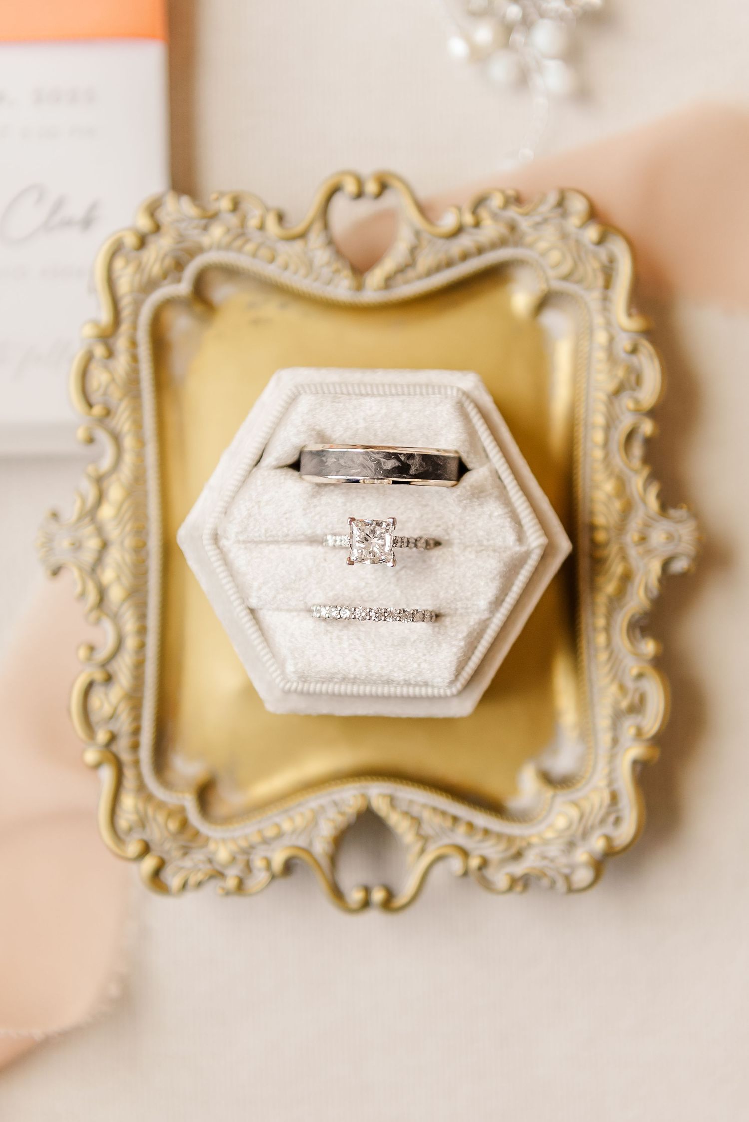 Vintage ornate cream-colored frames with antique photos arranged in a horizontal row against a soft peachy background.
