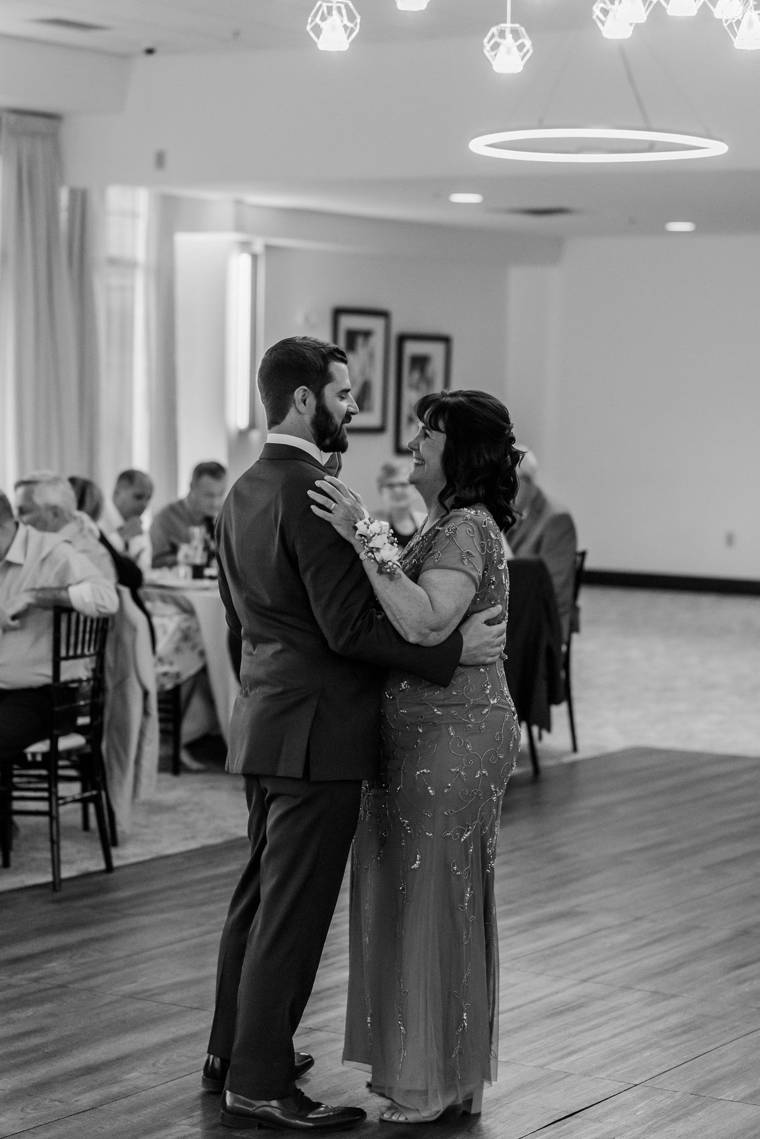 Black and white photo series showing couples dancing together at an elegant indoor venue with hardwood floors.