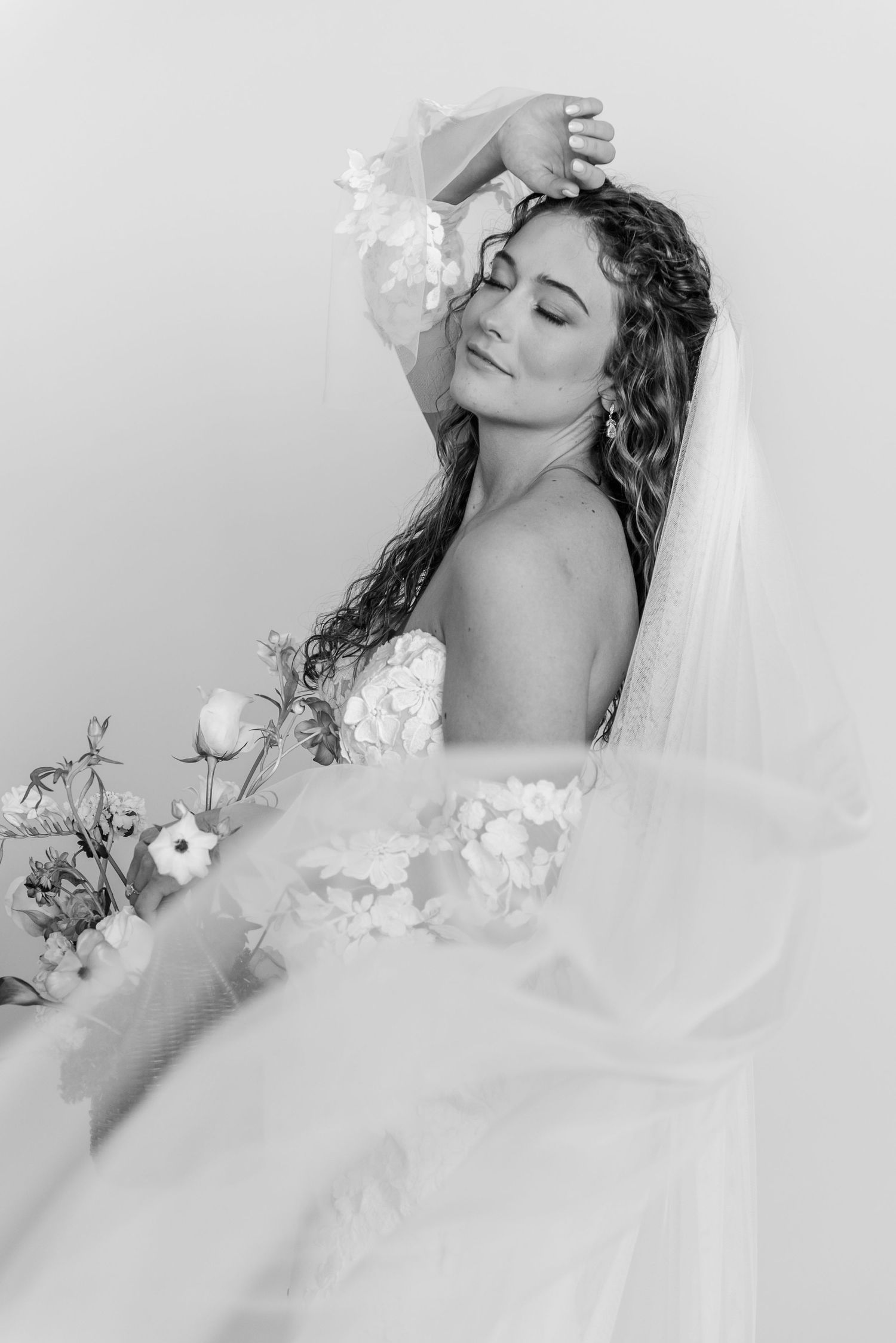 Dreamy black and white bridal portrait with delicate floral details.