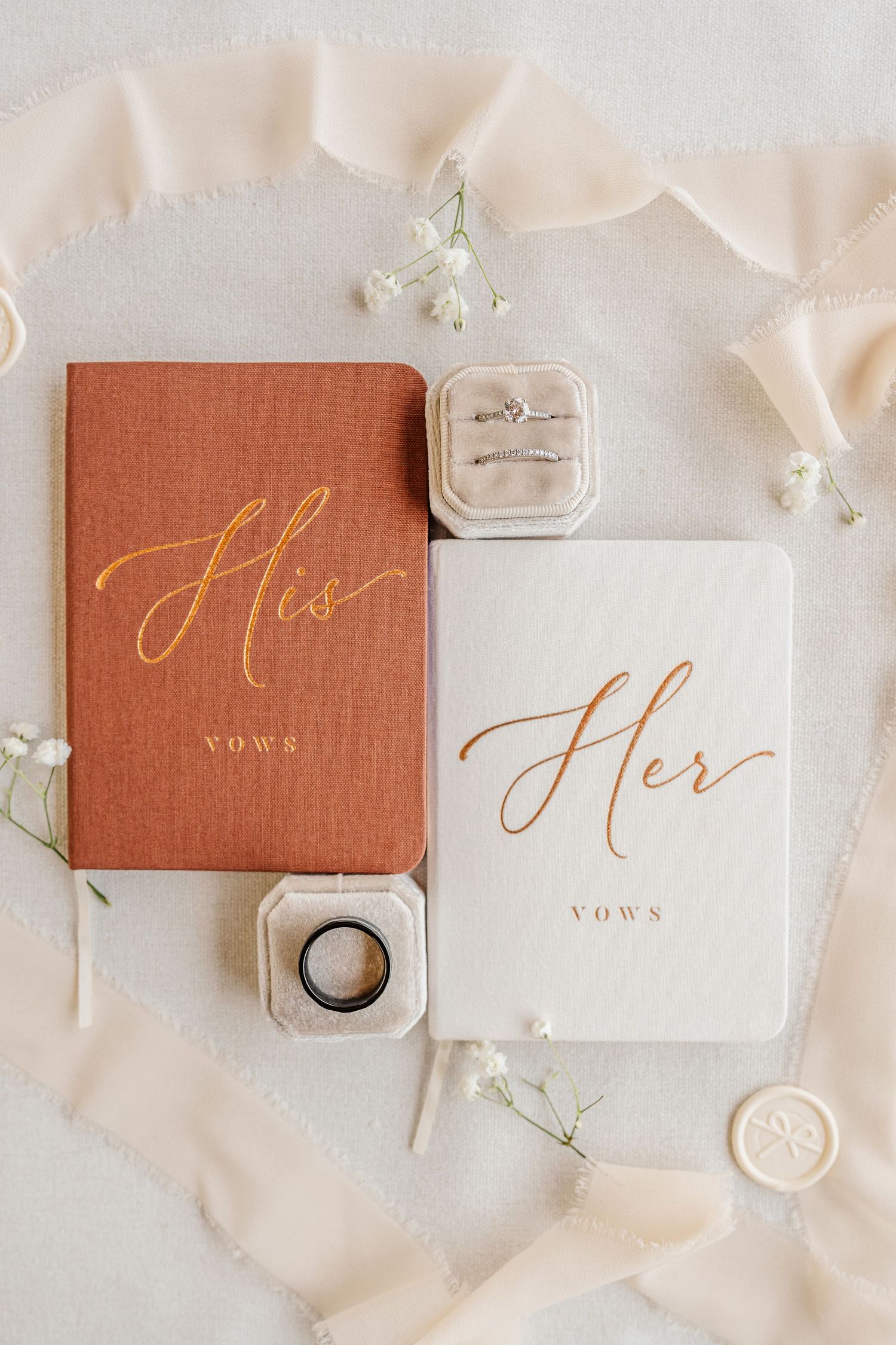 Wedding vow books in terracotta color with gold calligraphy and styling details.
