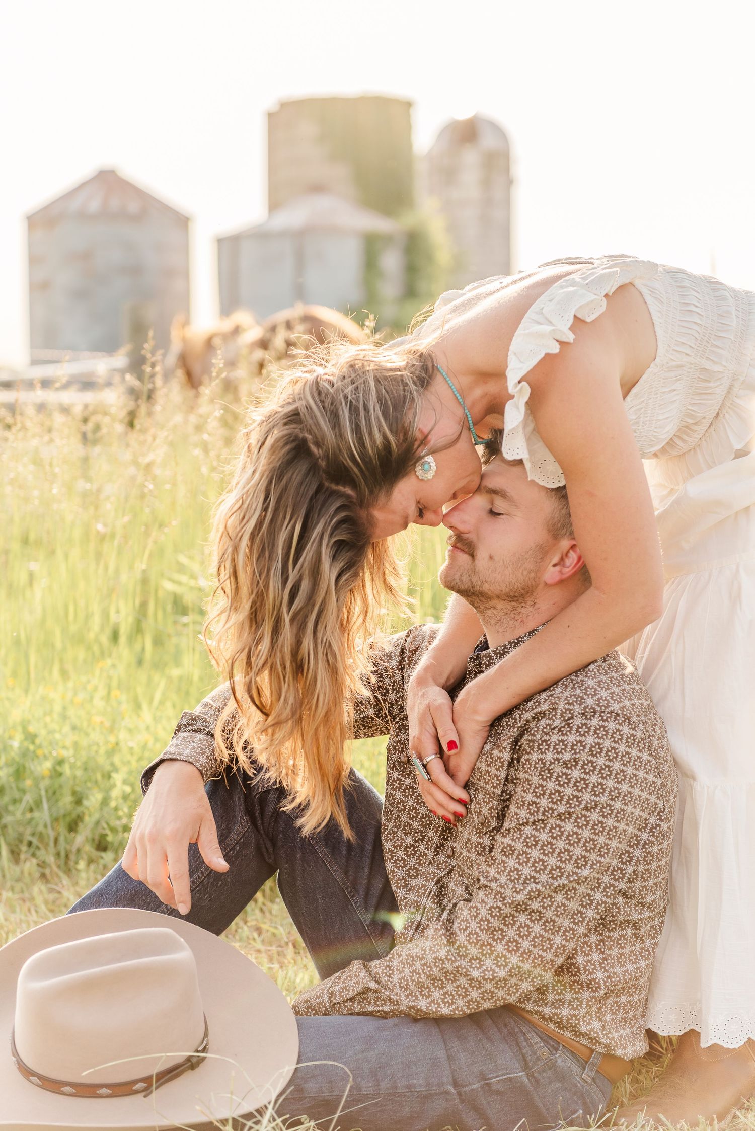 Couple sharing intimate moments while relaxing in rustic farm setting.