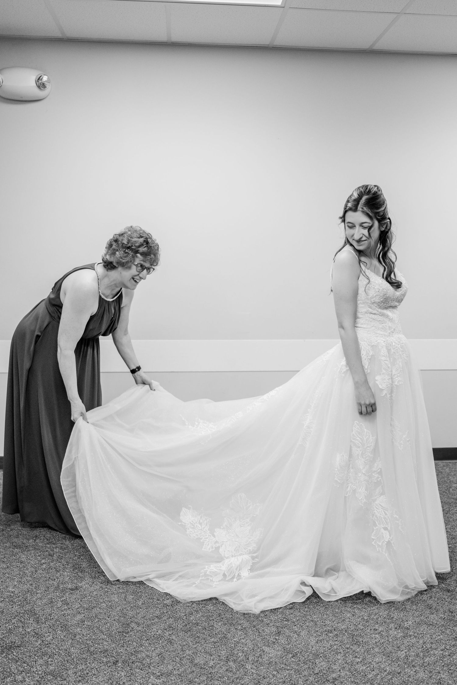 Sequence of black and white photos showing bridesmaids in dark dresses helping adjust a bride's flowing white gown.