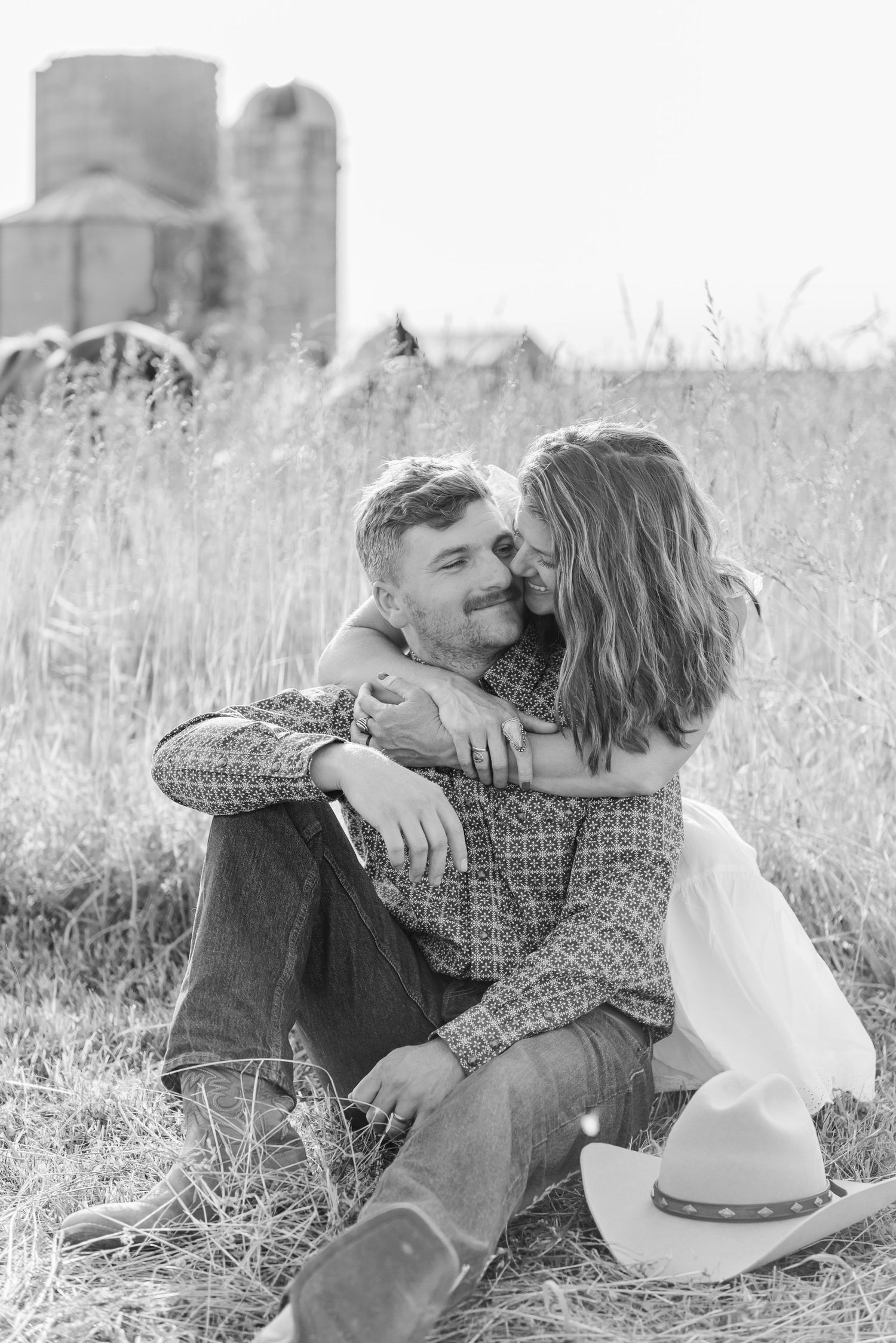 A black and white series showing an intimate moment between a couple in a field.