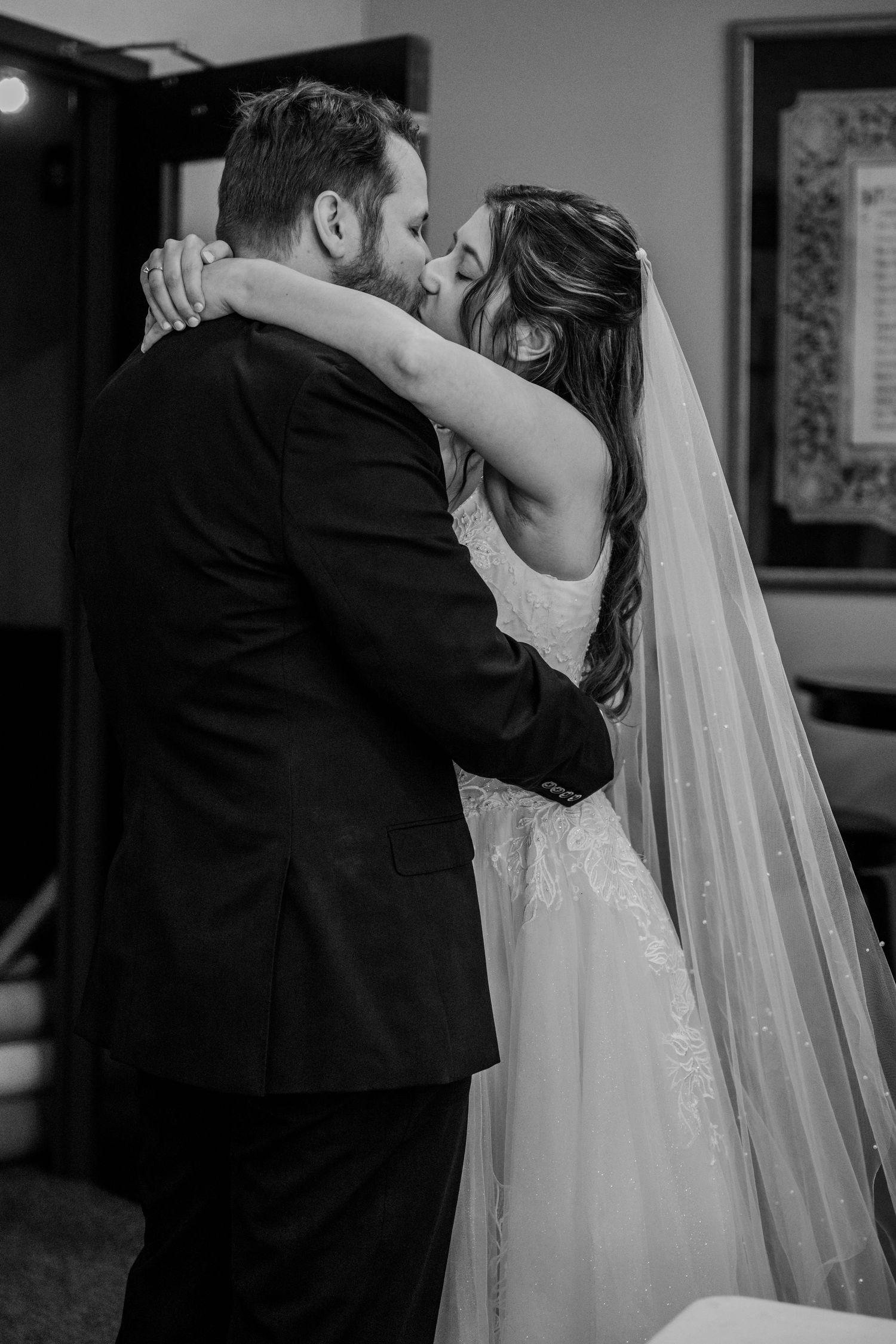 Black and white wedding sequence showing a romantic embrace with flowing white veil.