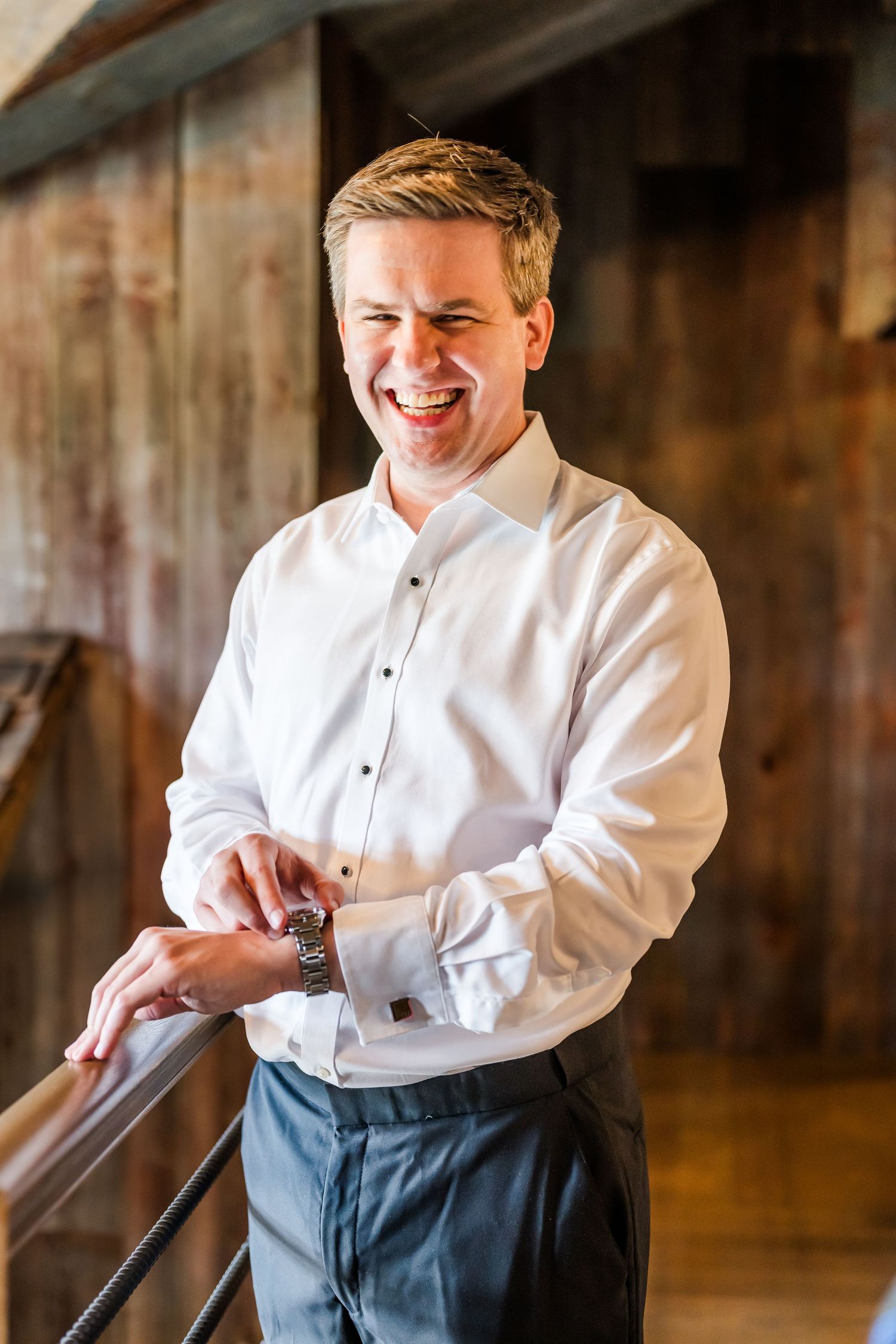 Person adjusting cufflinks while wearing formal white dress shirt and dark pants. The Old Barns at Dry Run Farms in Williamsport, OH.
