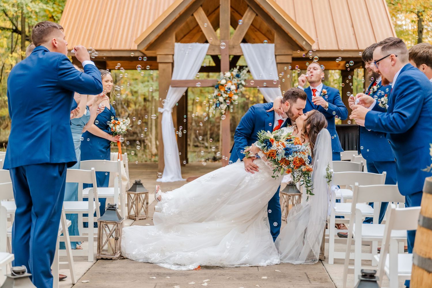 Wedding ceremony setup under a rustic wooden pavilion with white chairs and floral decorations. Four Seasons Barn Wedding & Event Venue