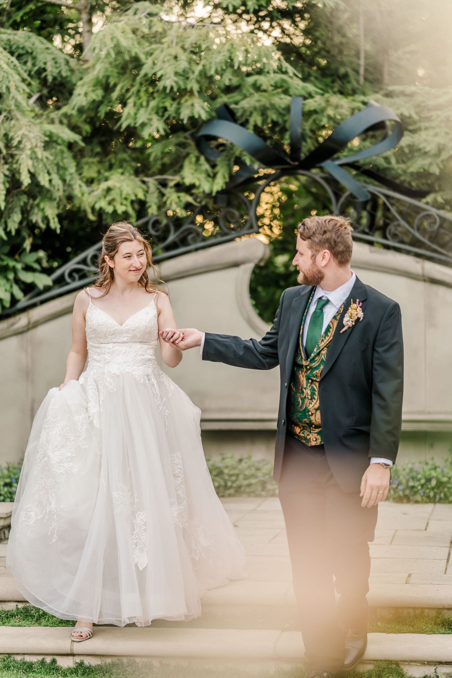 Garden wedding portraits showing couple dancing and twirling in formal attire.