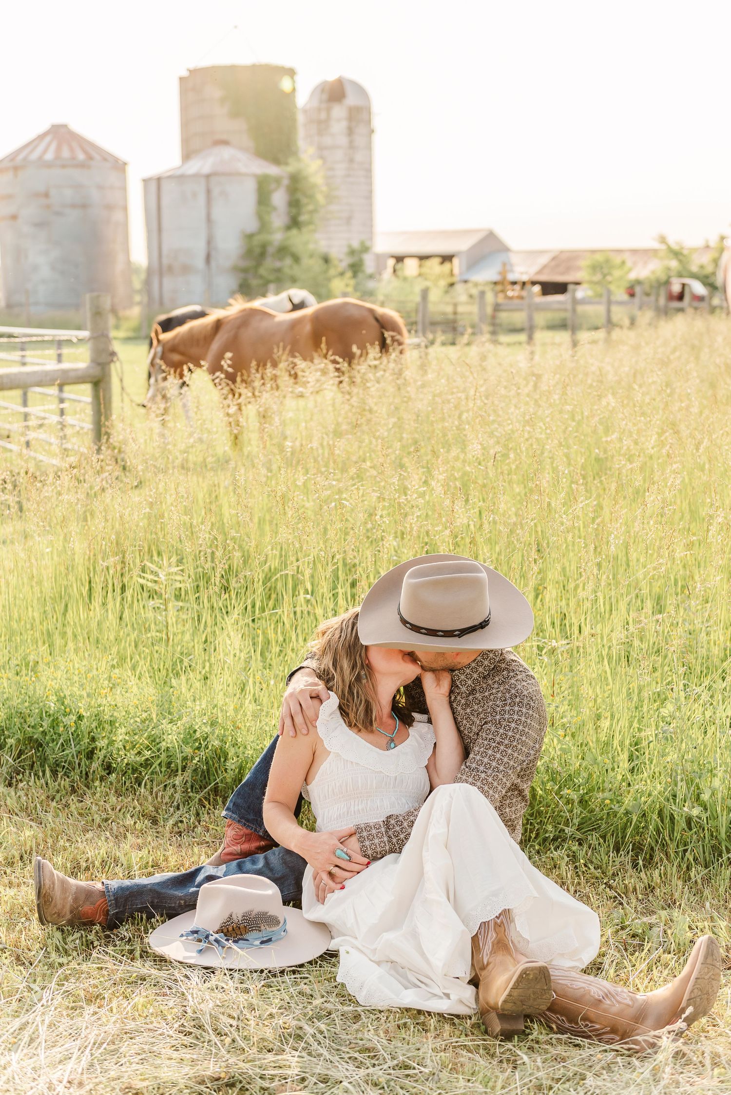 A romantic countryside picnic scene with grain silos in the background during golden hour.