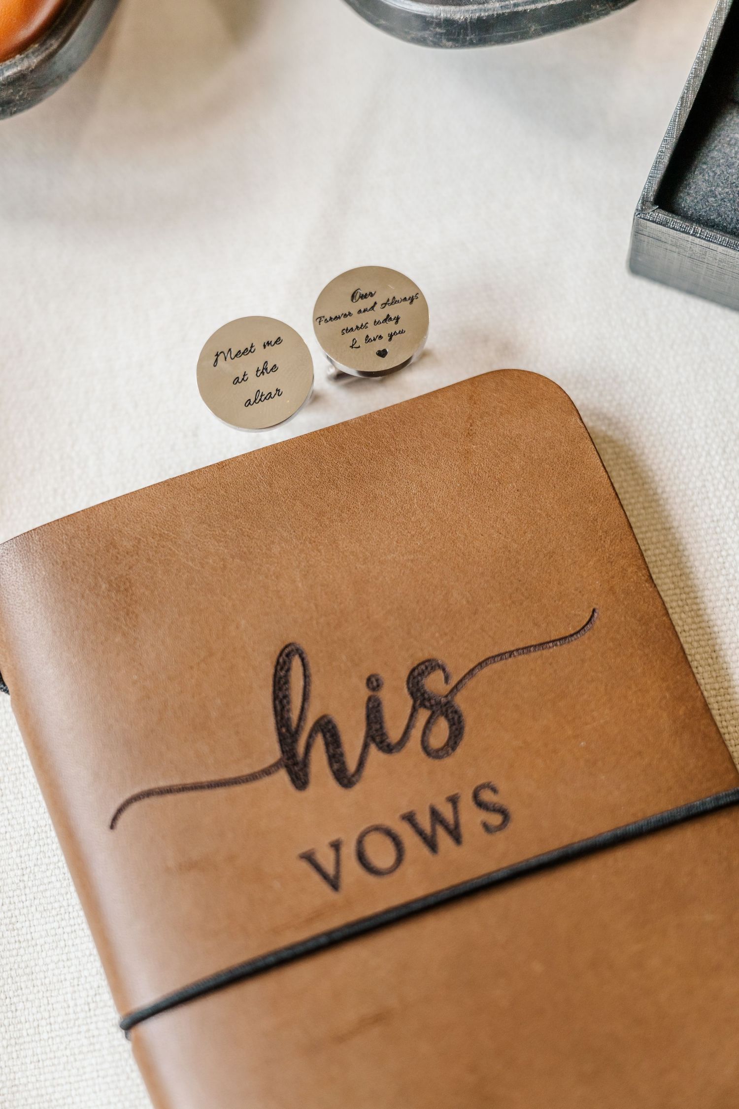 A brown leather notebook with 'VOWS' written on the cover in elegant script.