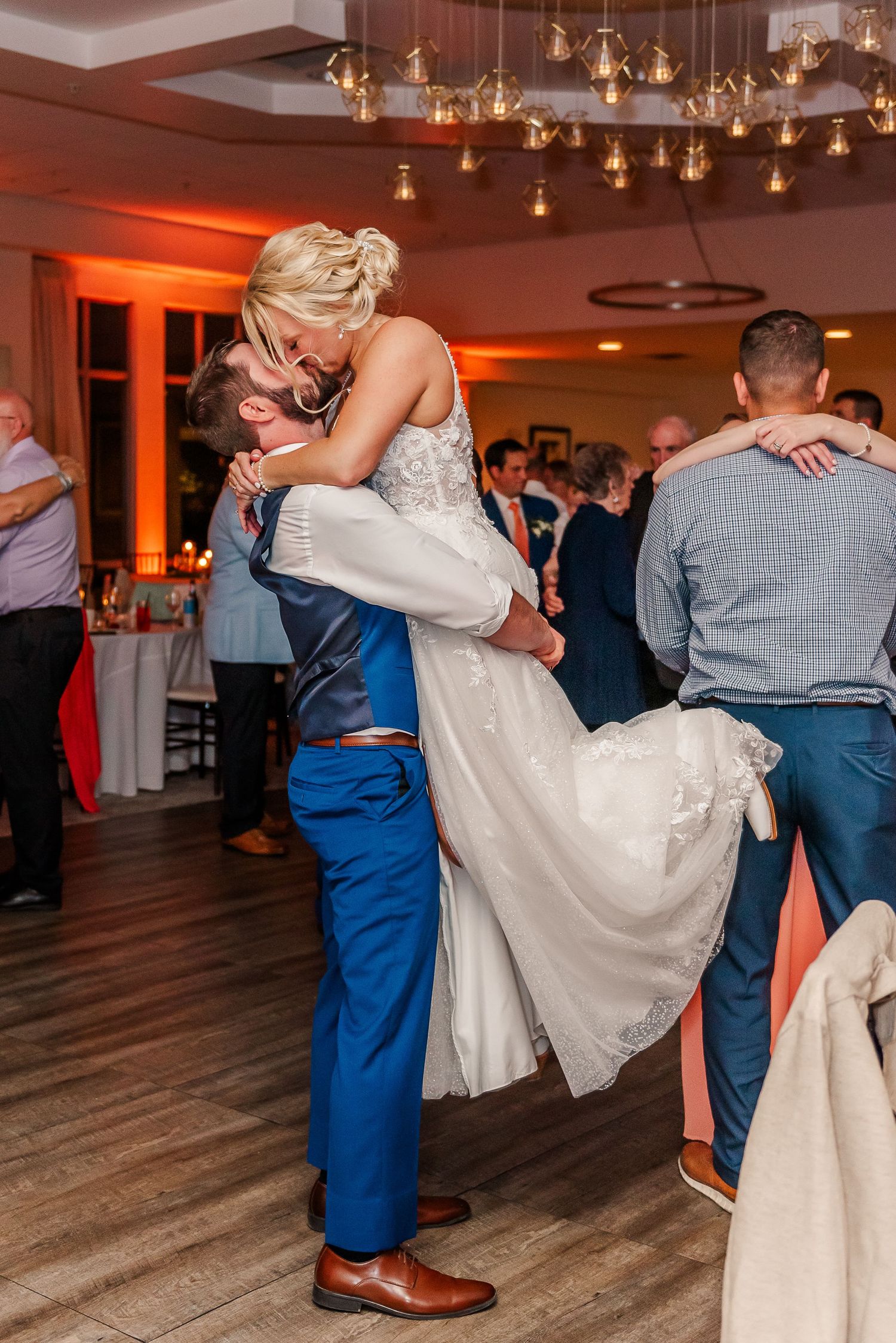 A sequence of dance moves showing a couple performing a romantic dip on a wooden dance floor at a wedding reception.