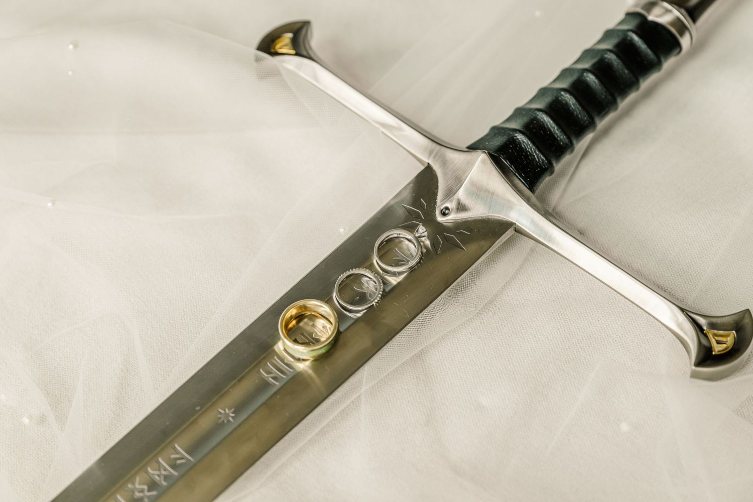 A collection of katana sword blades arranged in a row showing their detailed craftsmanship and metalwork patterns.