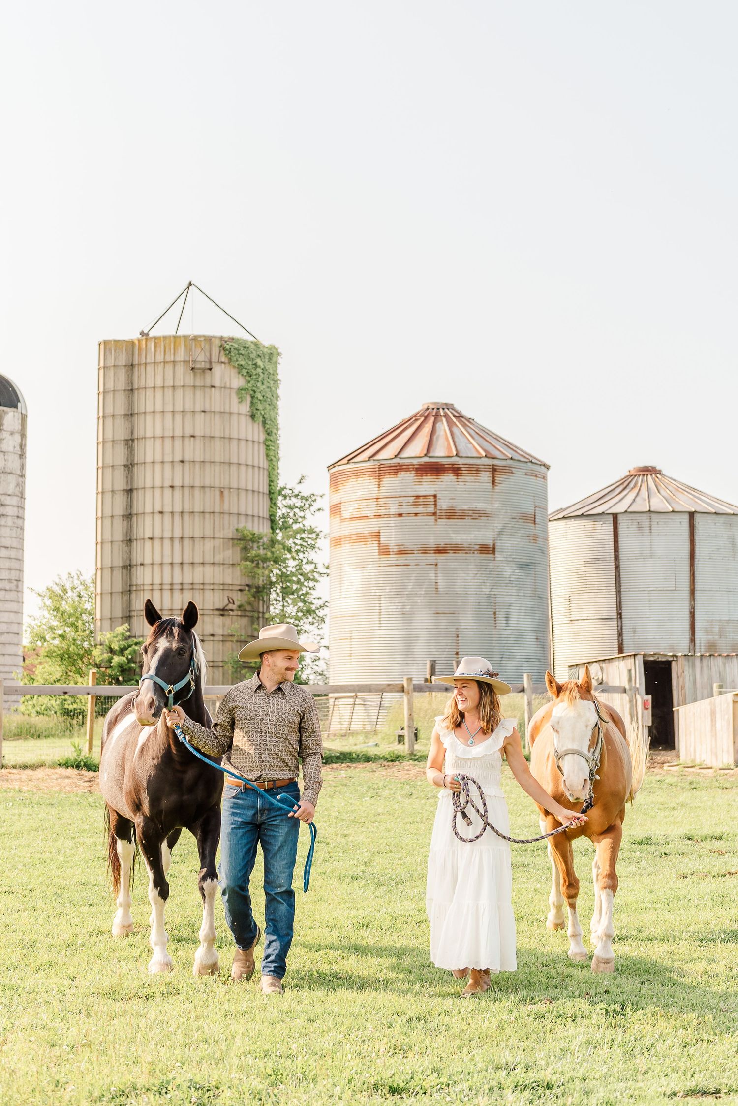 Three connected photos show a couple posing with horses near rustic grain silos in a pastoral farm setting.
