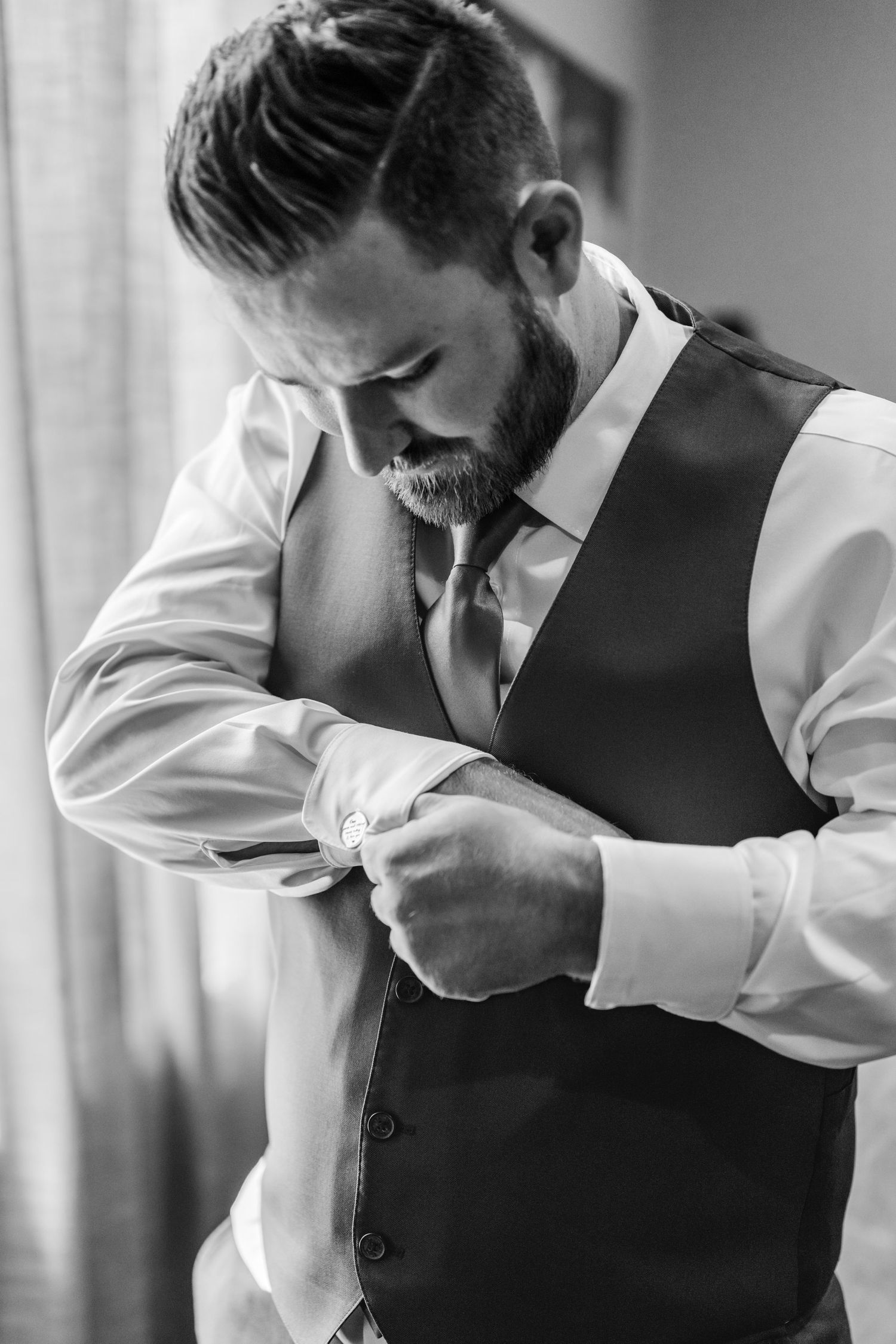 Close-up shots of someone adjusting their formal attire and vest before an event.