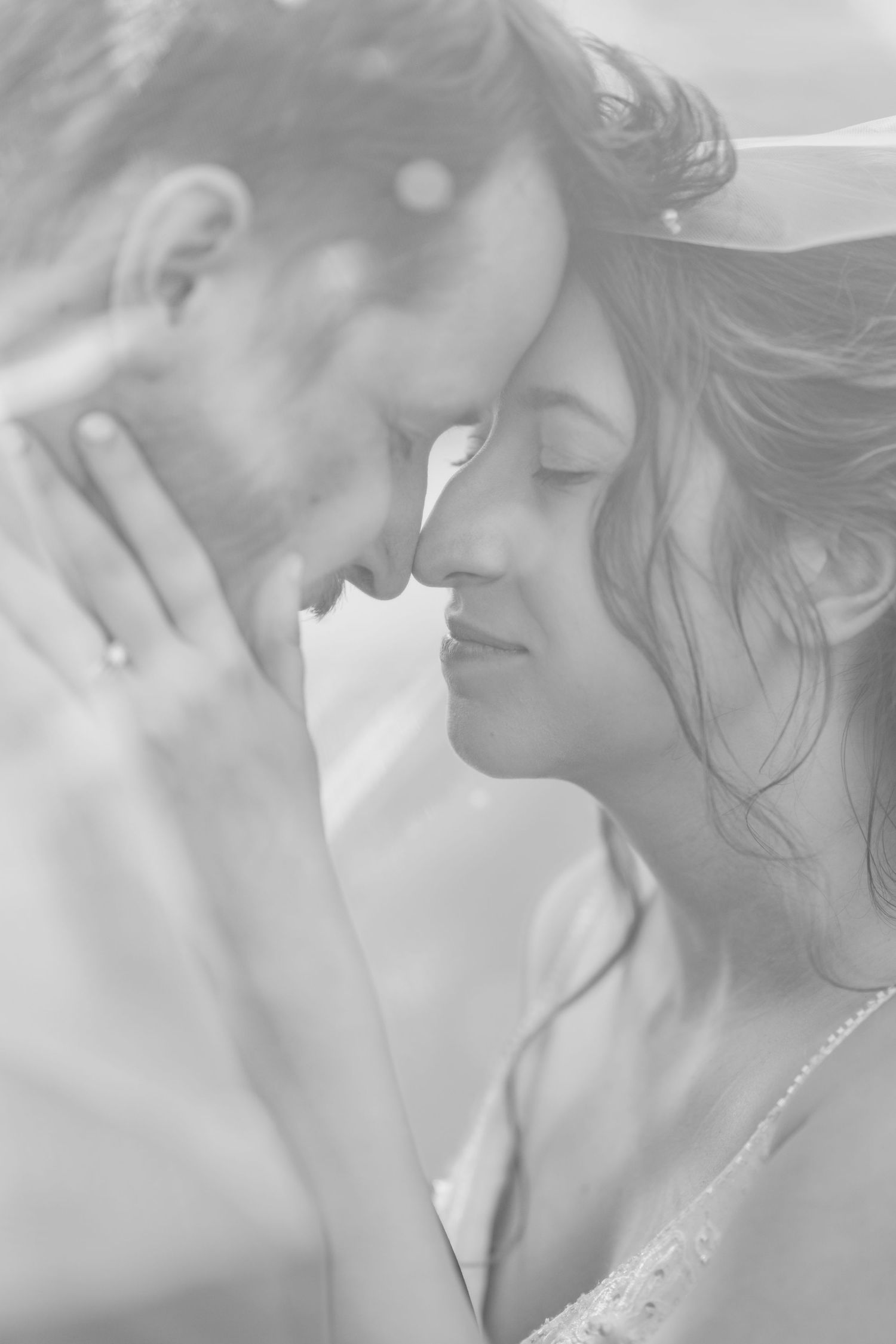 Soft focus intimate wedding portrait sequence in black and white with delicate lighting.