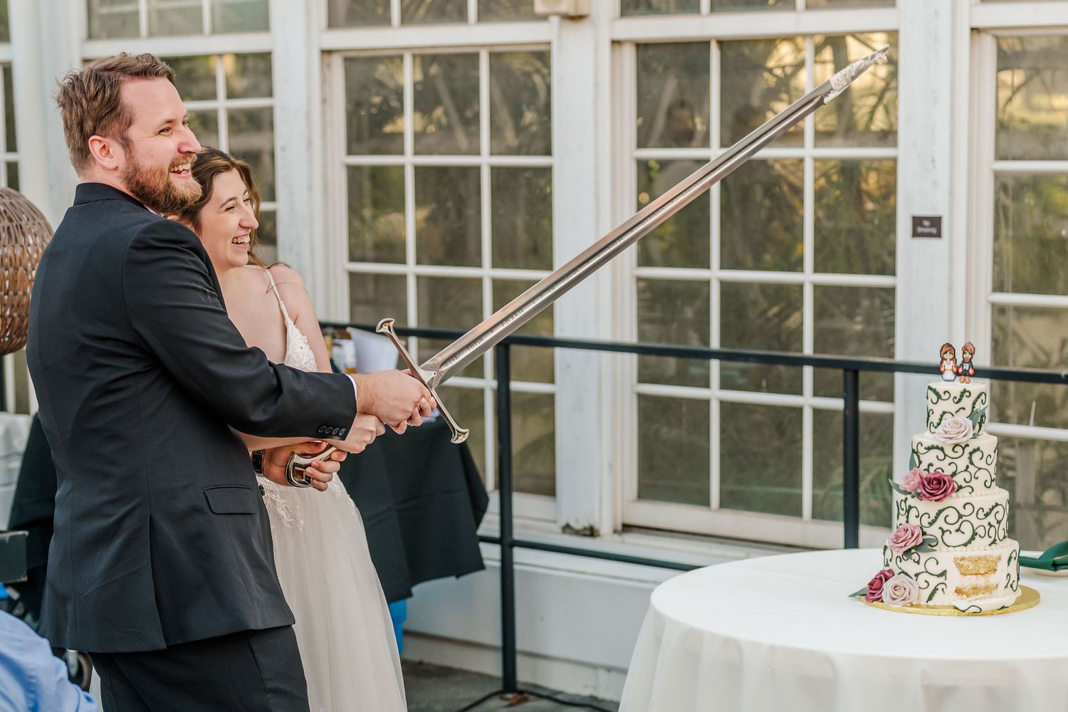 Newlywed couple shares their first dance in an elegant ballroom with large windows and ornate decorations.