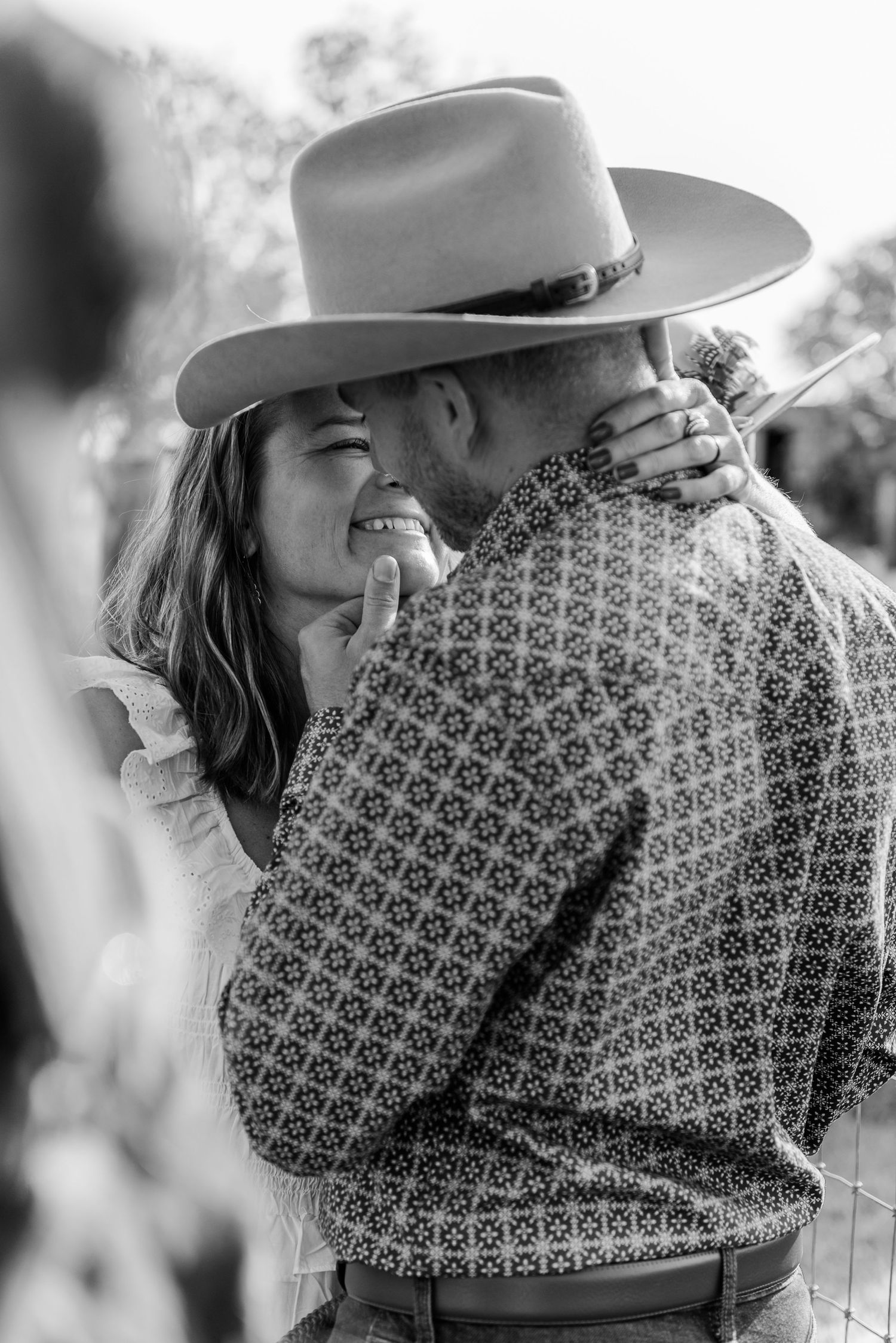 A romantic black and white moment captured between two people wearing western style clothing.