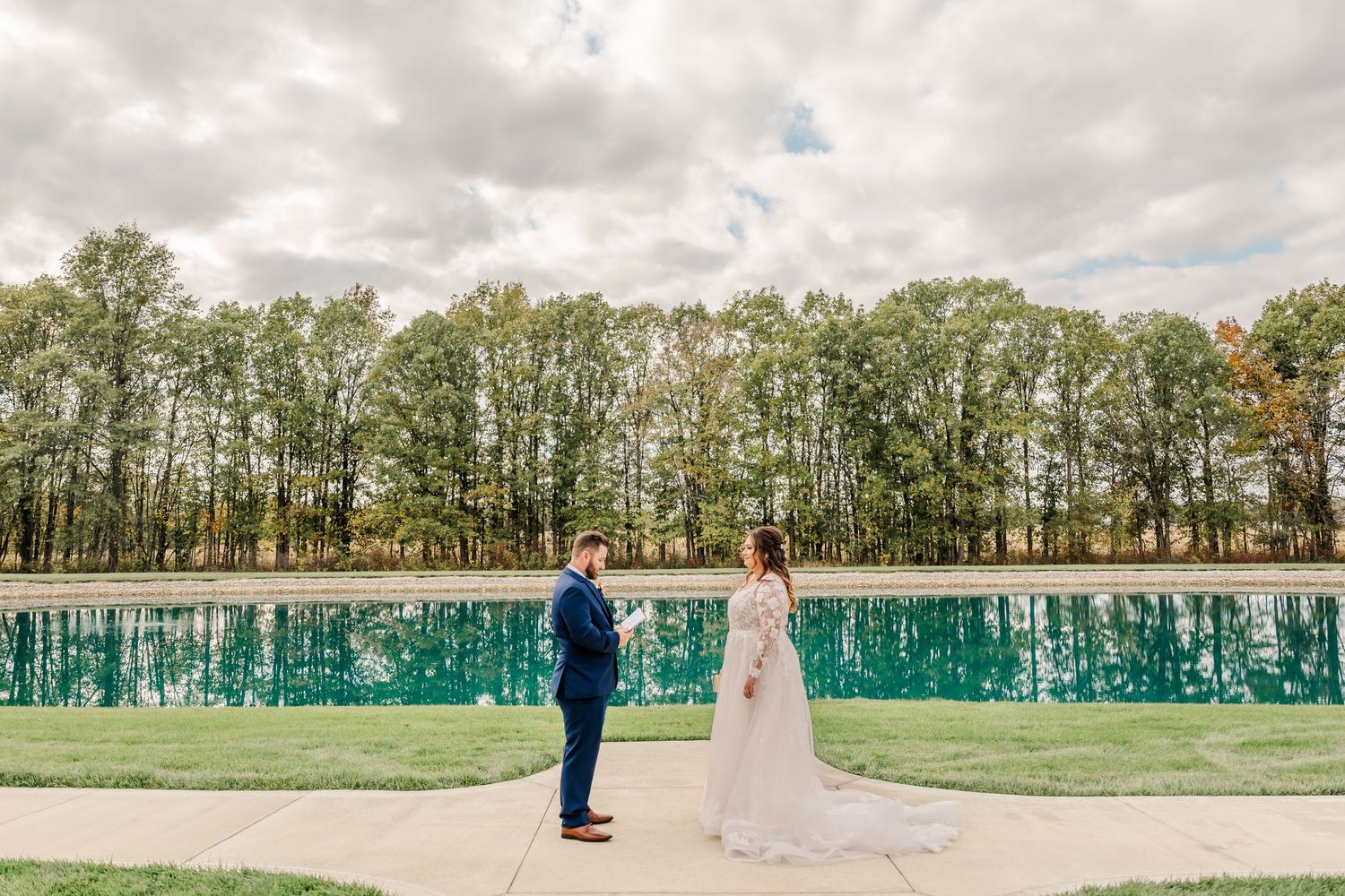 A panoramic view of a wedding venue with green trees and cloudy skies in the background. Four Seasons Barn Wedding & Event Venue