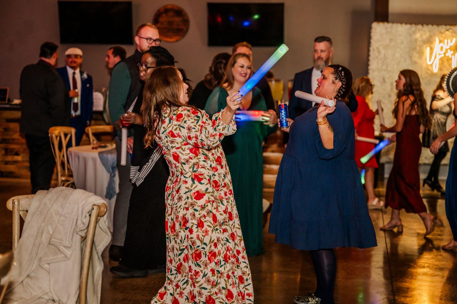 Wedding reception dance floor with guests dancing in colorful dresses and formal attire.Four Seasons Barn Wedding & Event Venue