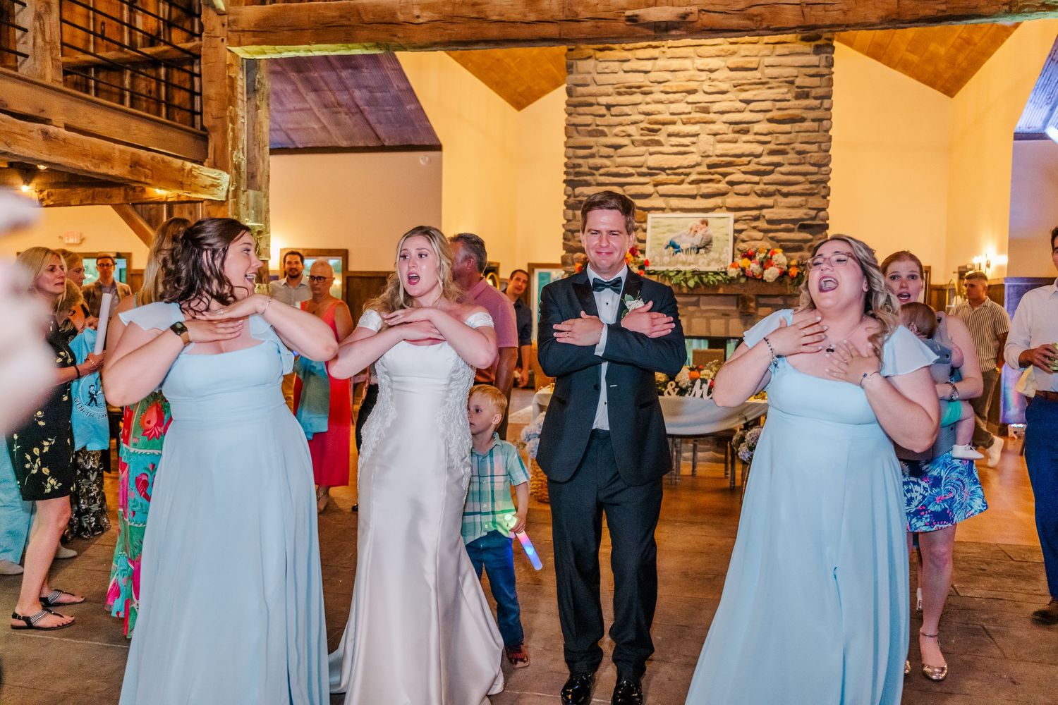 Wedding party members in light blue dresses and formal attire gathered in an elegant reception hall.